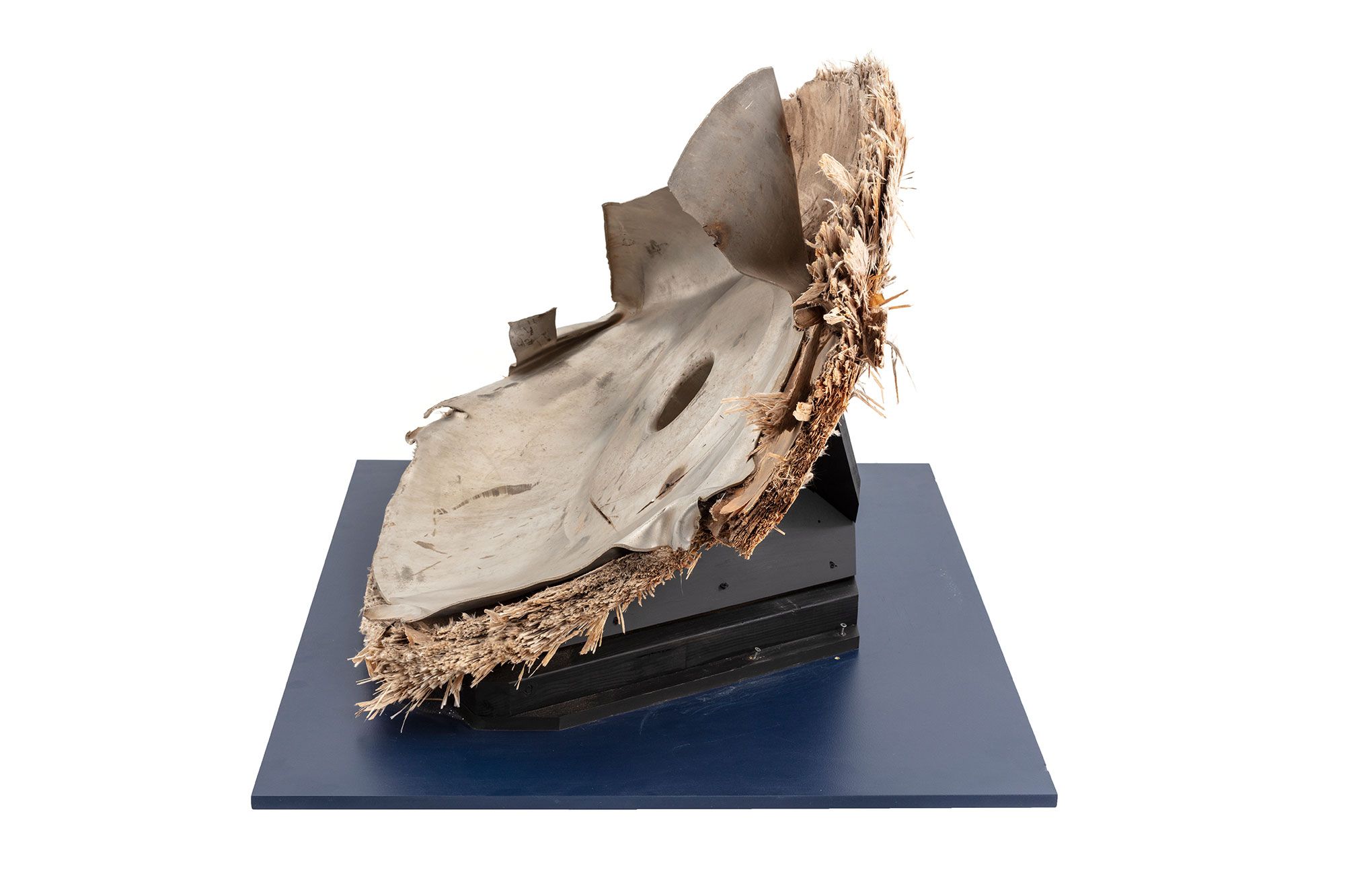 Space debris, Skylab space station, titanium/fibreglass, McDonnell Douglas Astronautics Co, USA, 1970-1972. The fragment is the end cap from pressurised oxygen tank from the Skylab space station. Originally the end of an enclosed cylinder, the titanium tank structure is torn and bent as a result of the stresses that ripped it away from the rest of the vessel. The exterior is covered by a composite insulation material with a woven fibreglass outer surface. A circular lid, protruding above the external insulation, covers an access hatch to the tank. A black and red wire, possibly originally connected to an external power source or sensor, is attached to the lid.