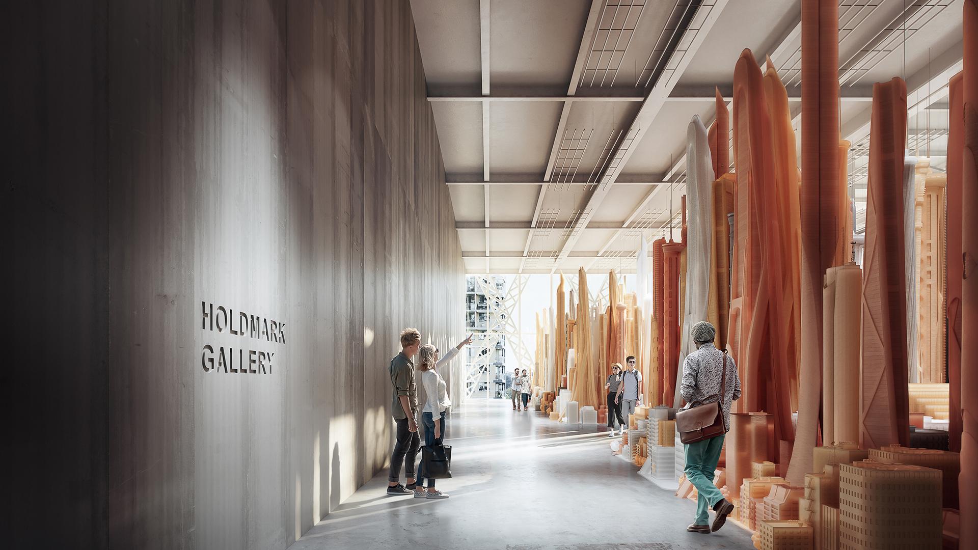 A large gallery with a high ceiling, concrete walls and floor. There are people in the gallery looking at large orange sculptures.
