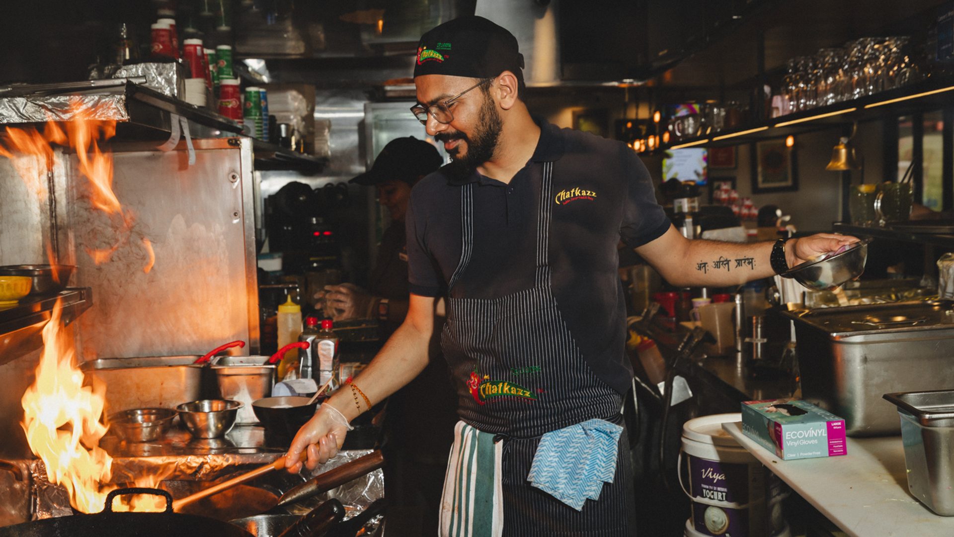 Chef cooking with fire in a kitchen.