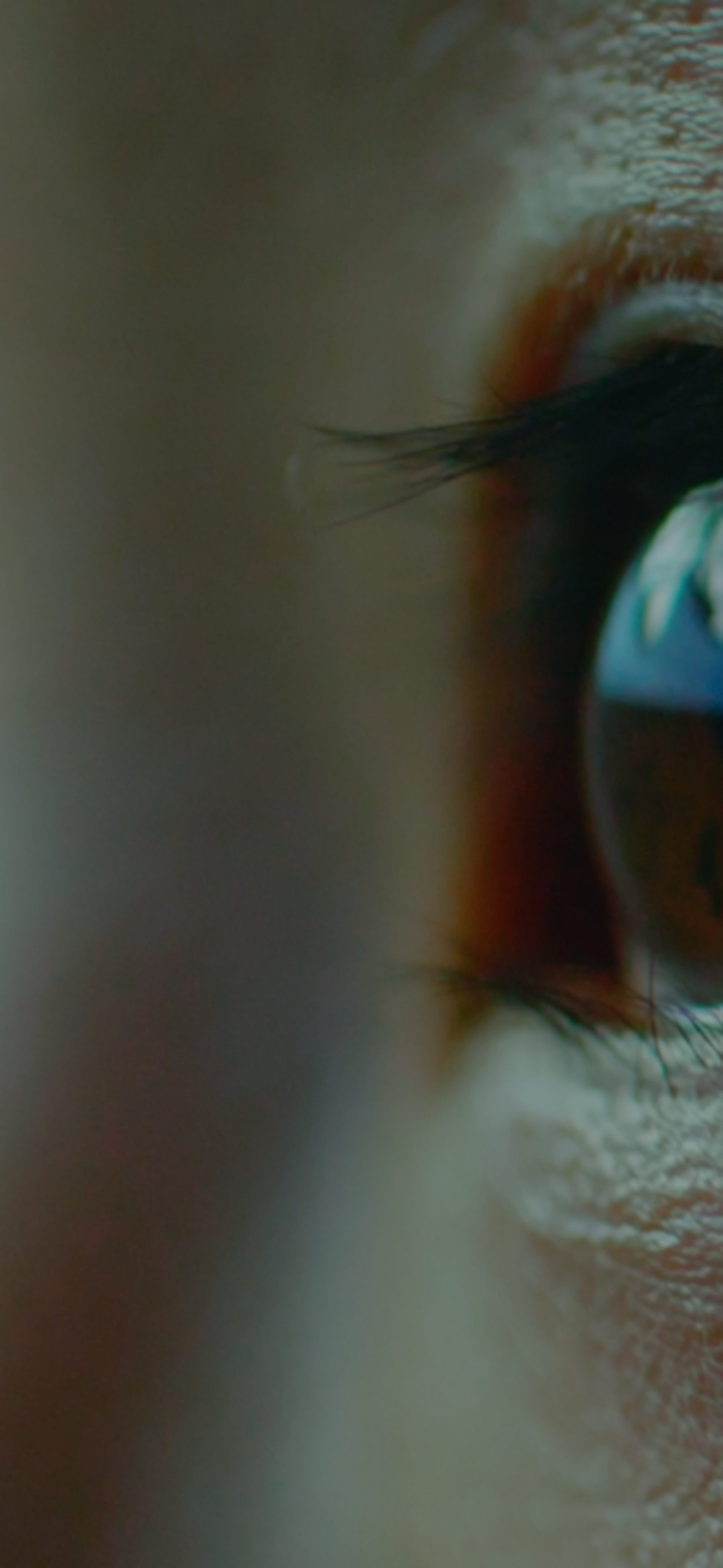Close up of eyes looking upwards with the corner of a screen reflected in the eye