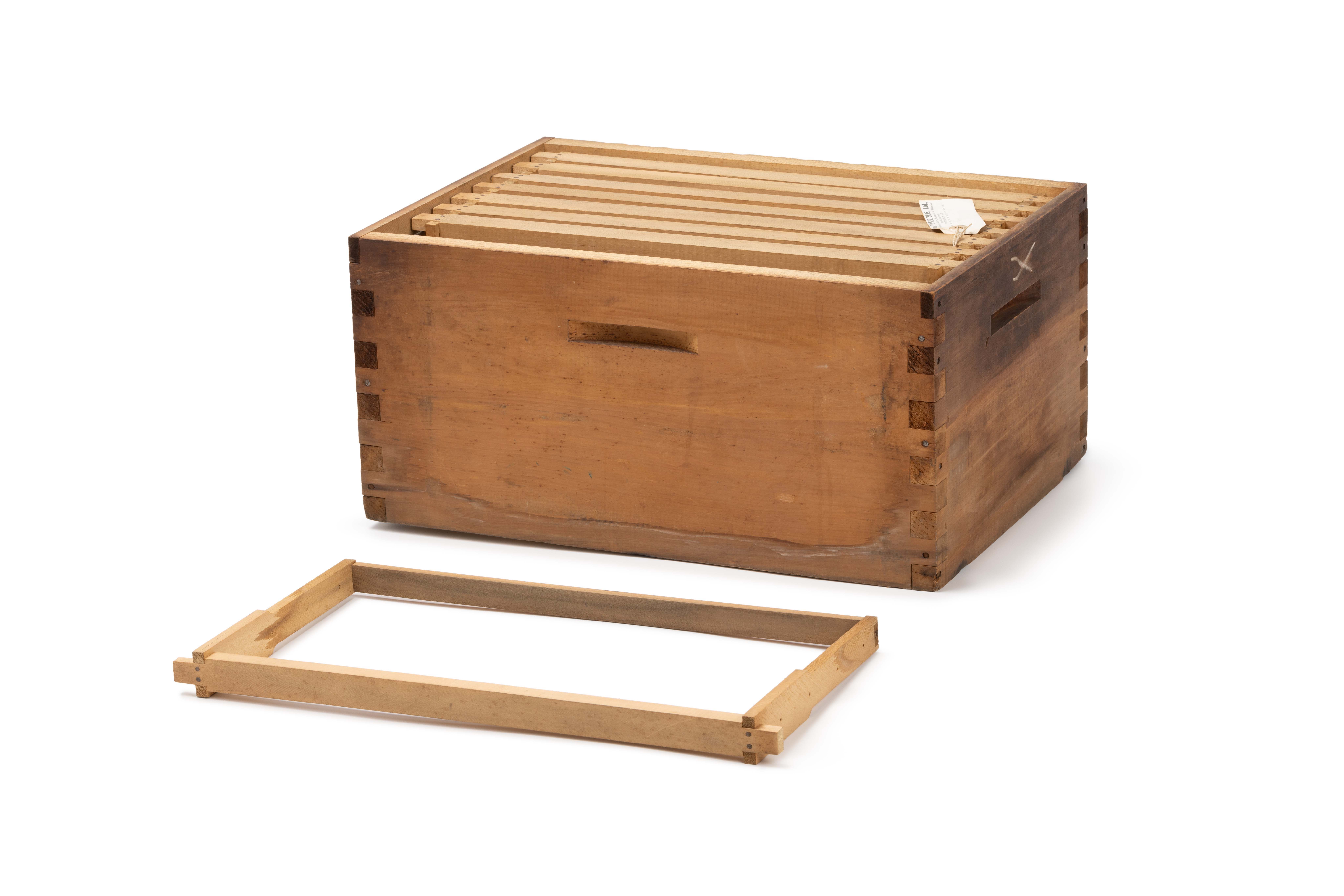 A rectangular single-body timber beehive with dovetailed corners and four grooved handles.