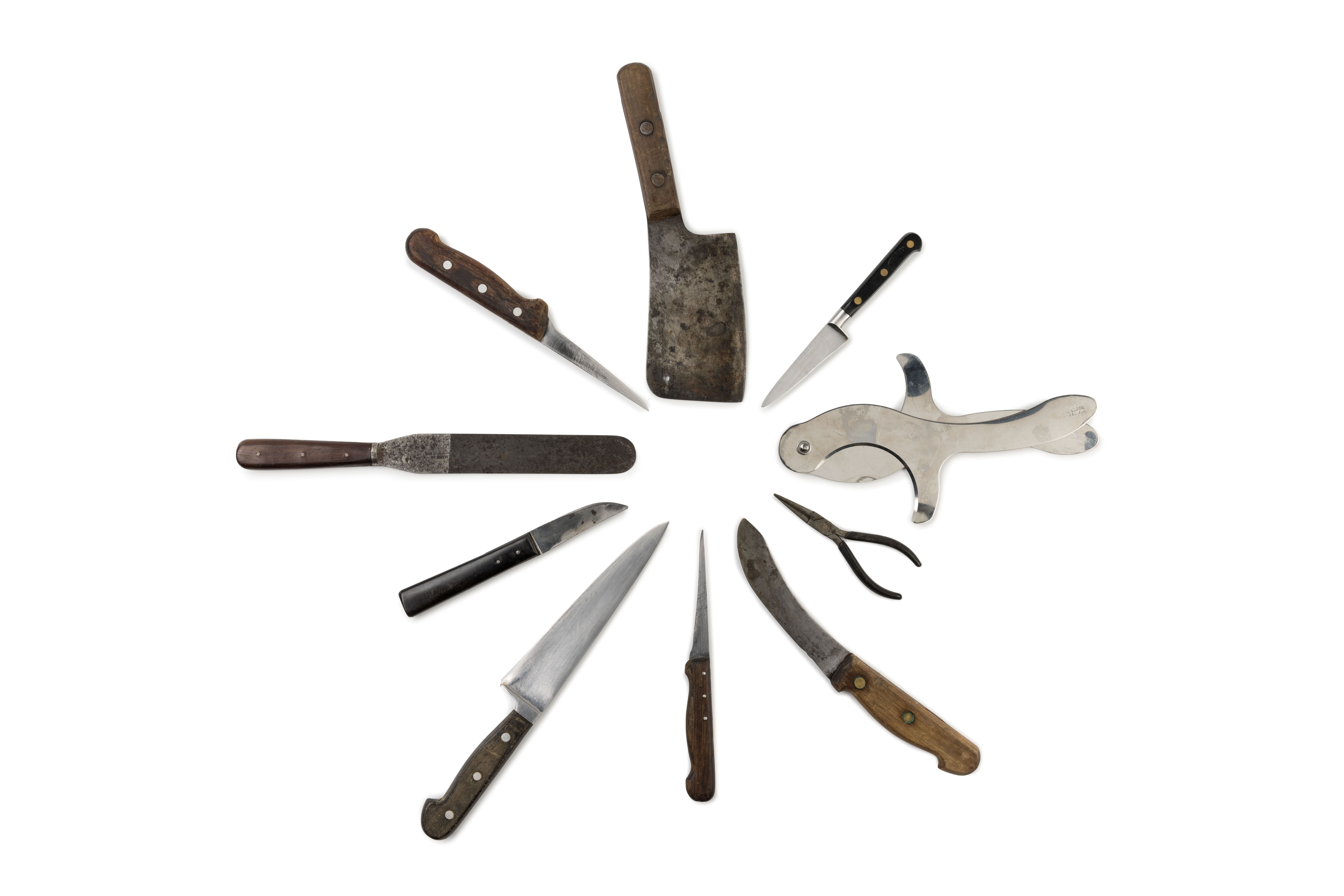 Kitchen knives and tools laid out in circle.