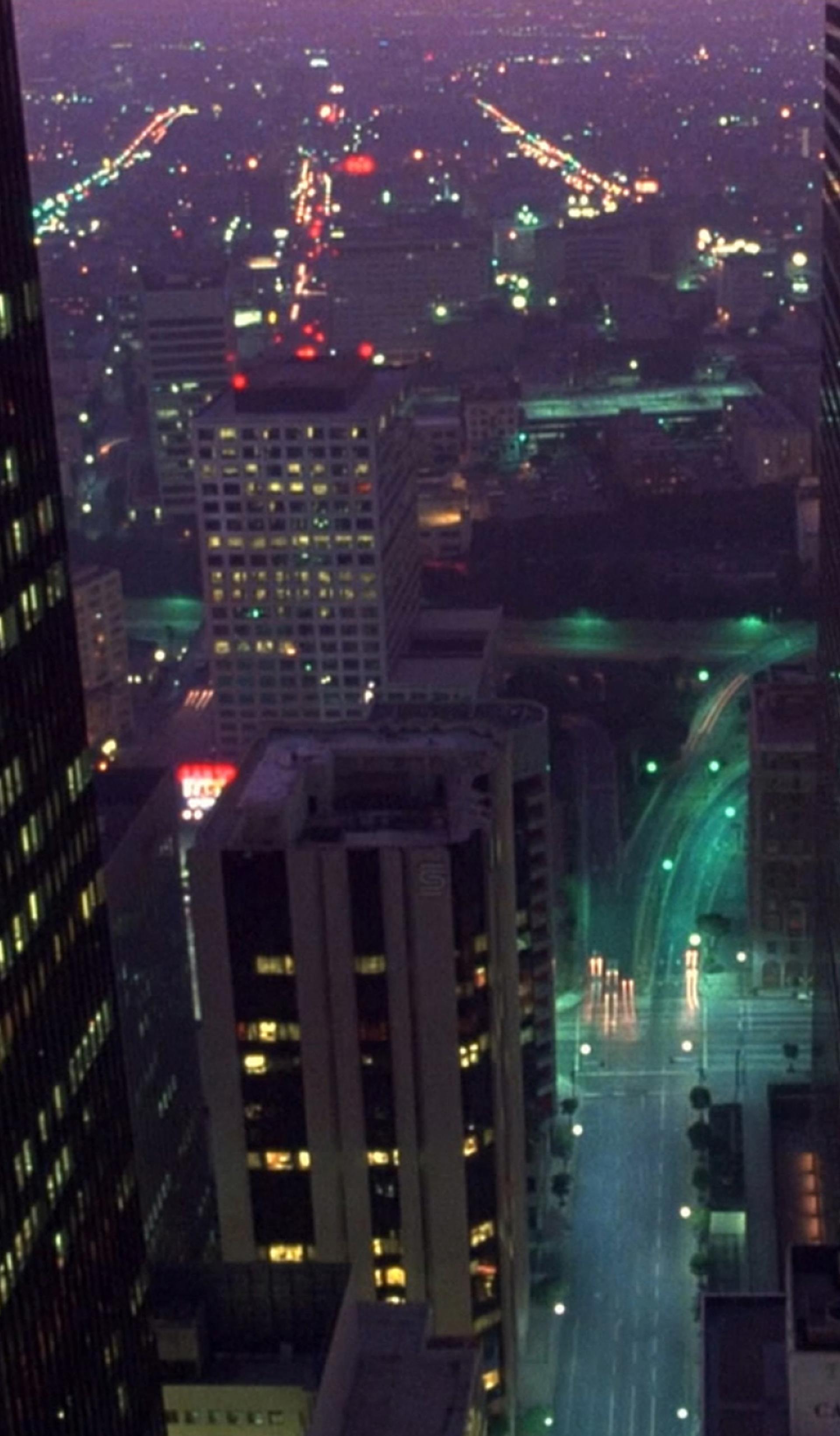 Cityscape at night with tall building in forefront