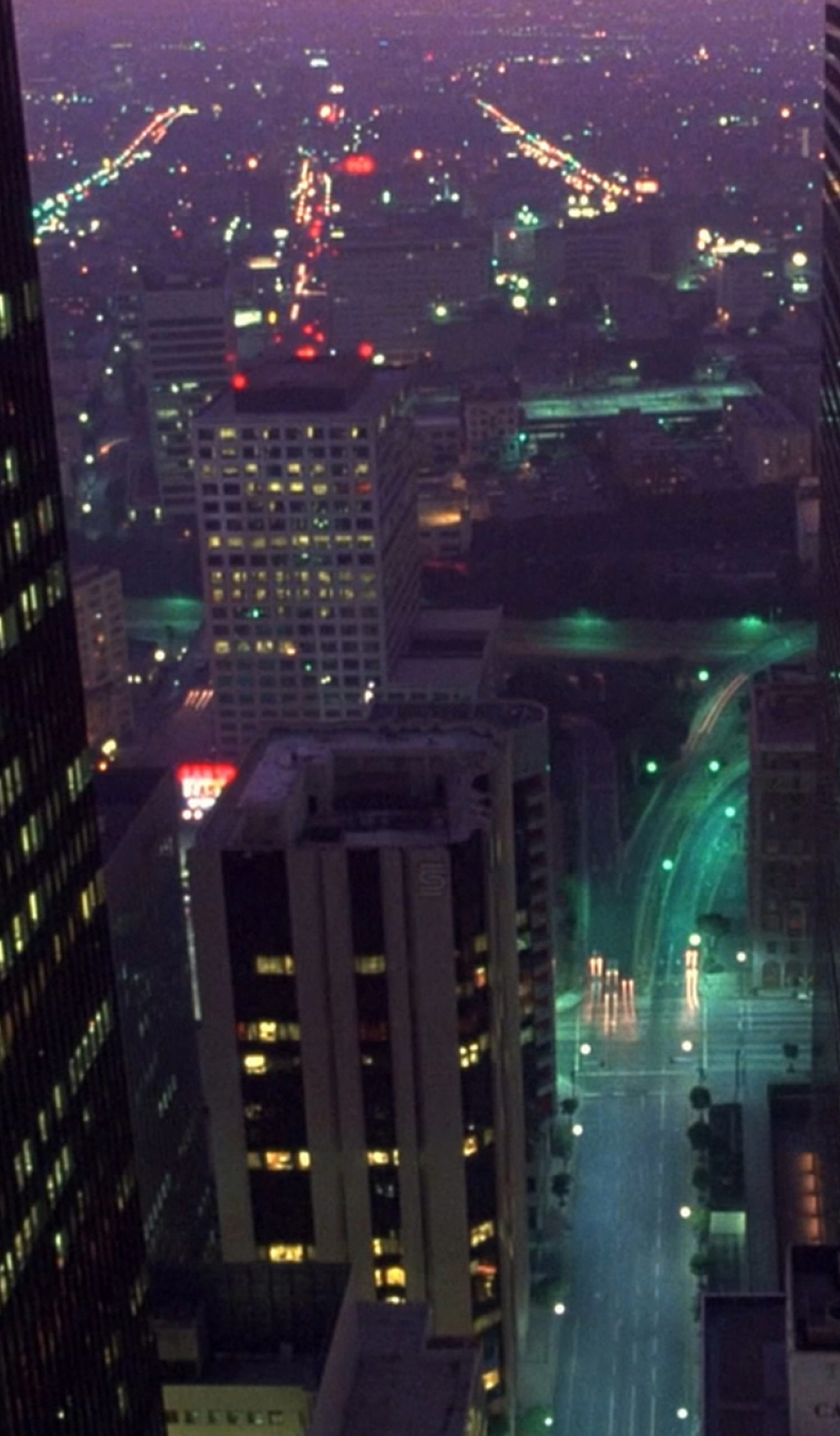 Cityscape at night with tall building in forefront