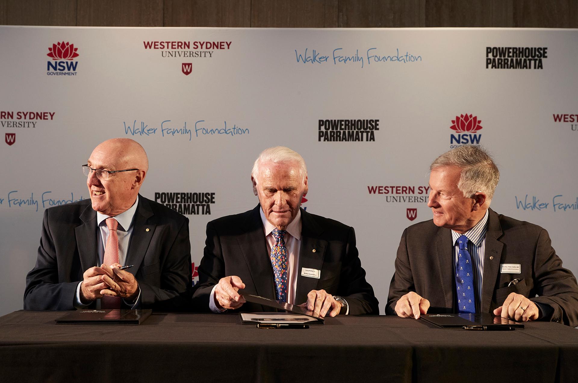 3 men in suits sitting with clipboards