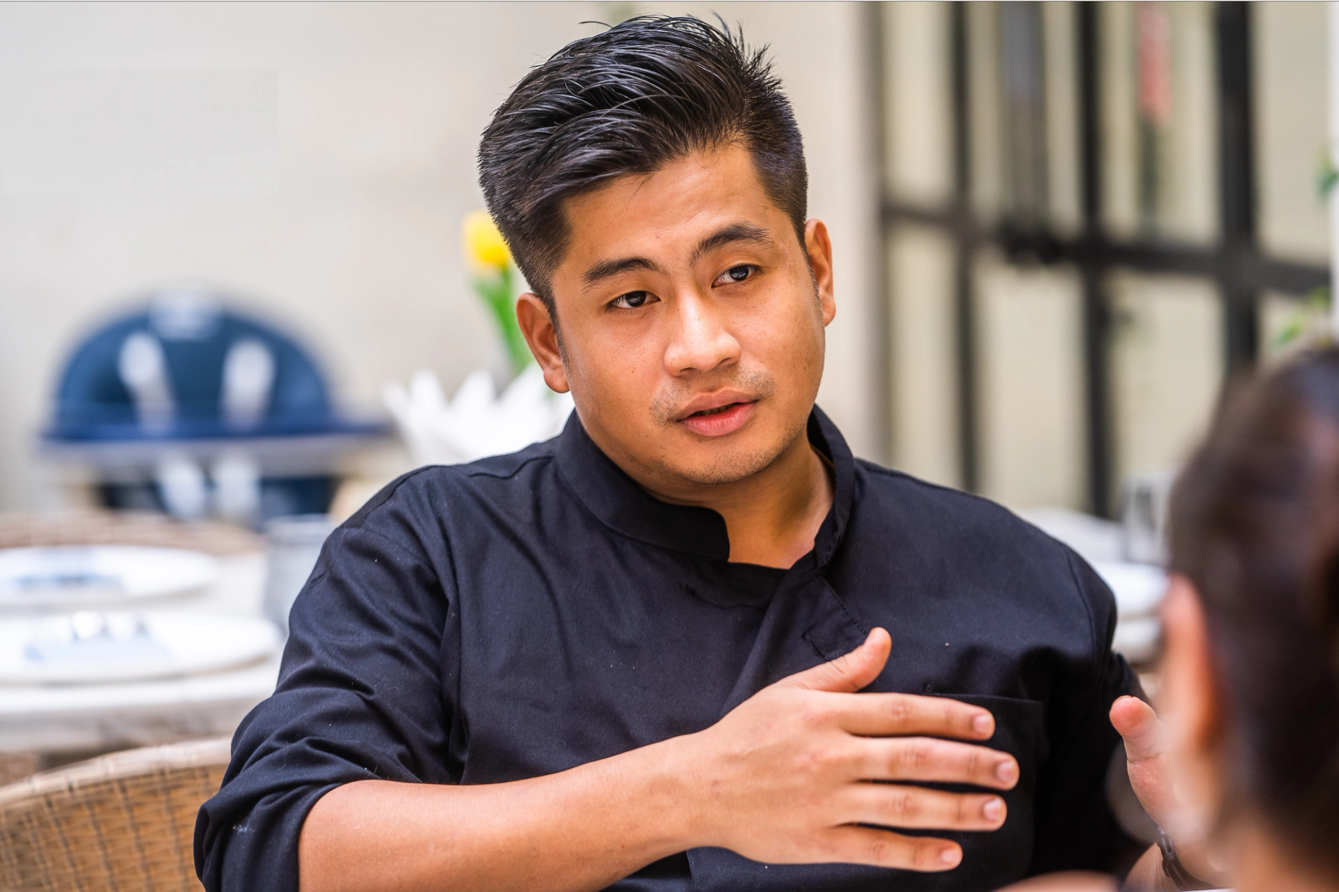A Manipuri man in a black chef’s uniform.
