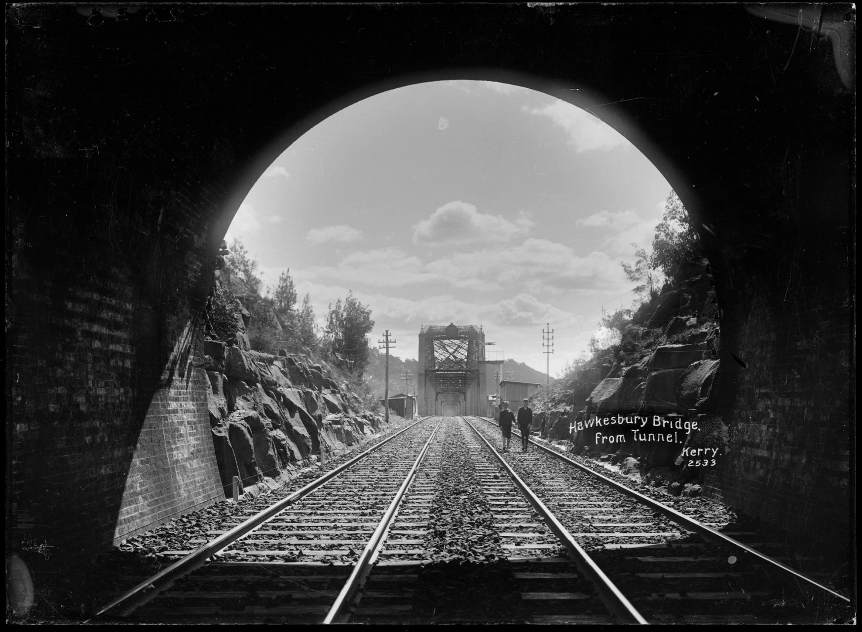 The end of a brick railway tunnel opening out onto a bridge.