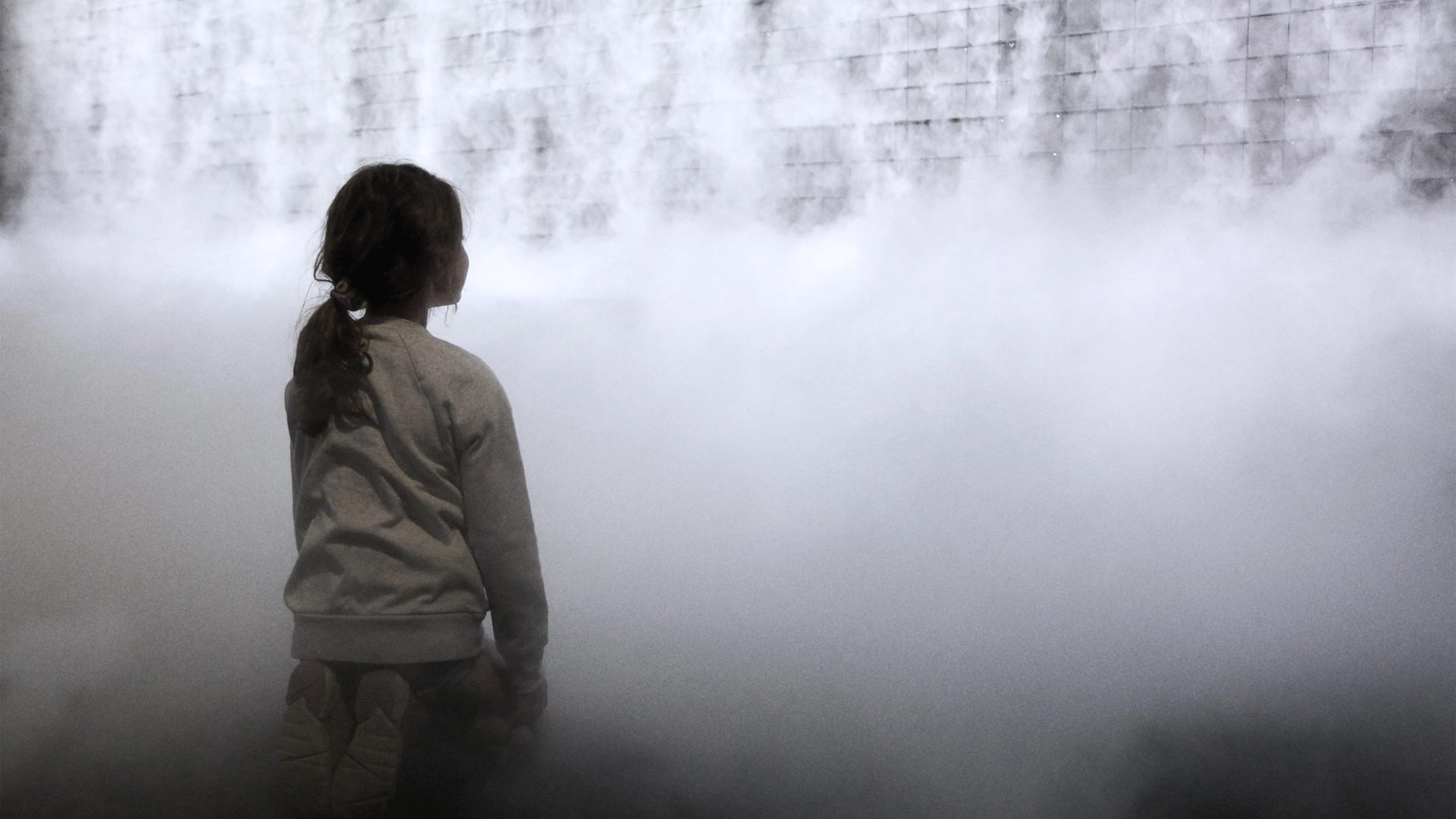 Little girl in front of cloud display, wall of smoke simulating cloud vapour
