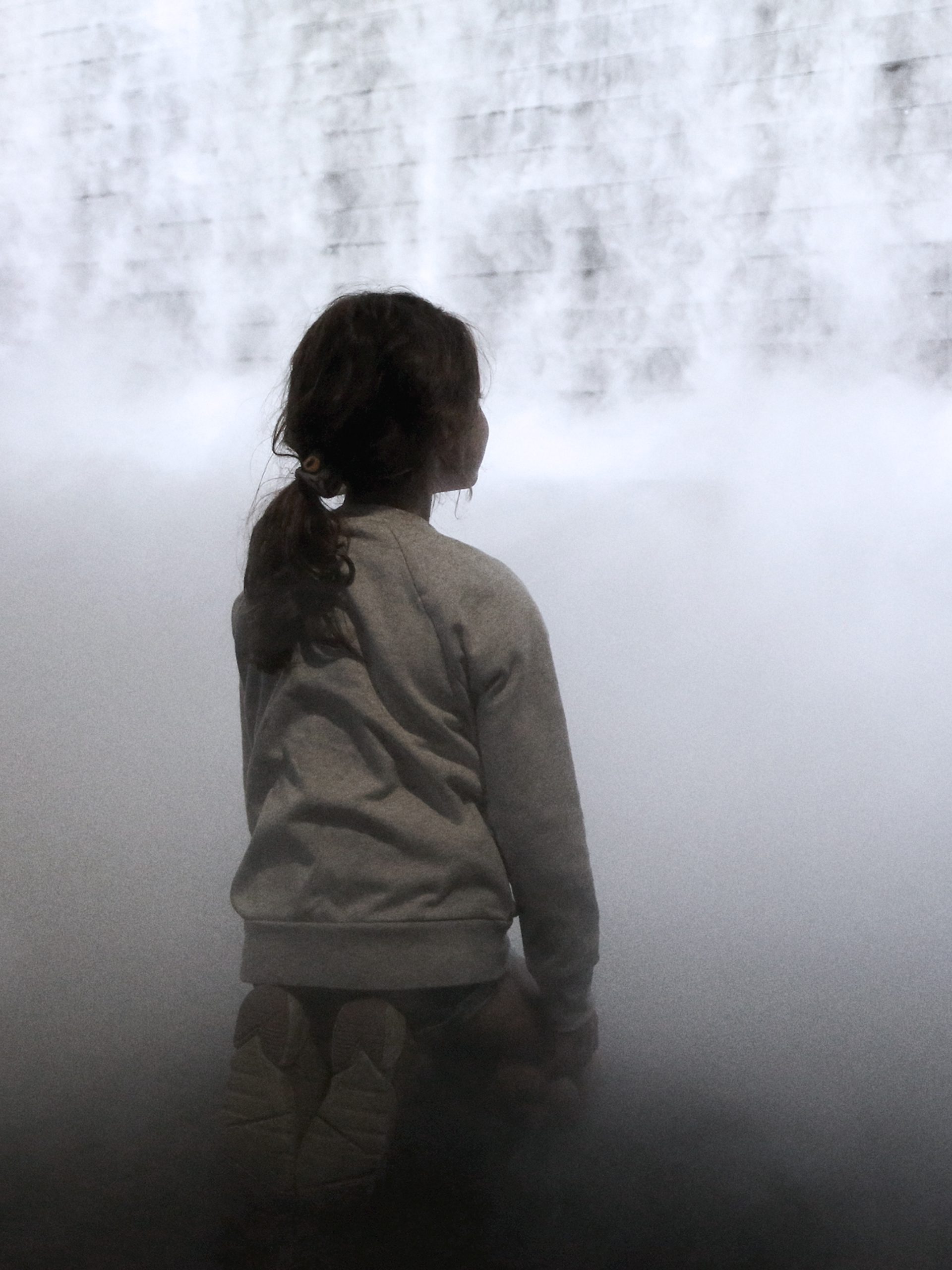 Little girl in front of cloud display, wall of smoke simulating cloud vapour
