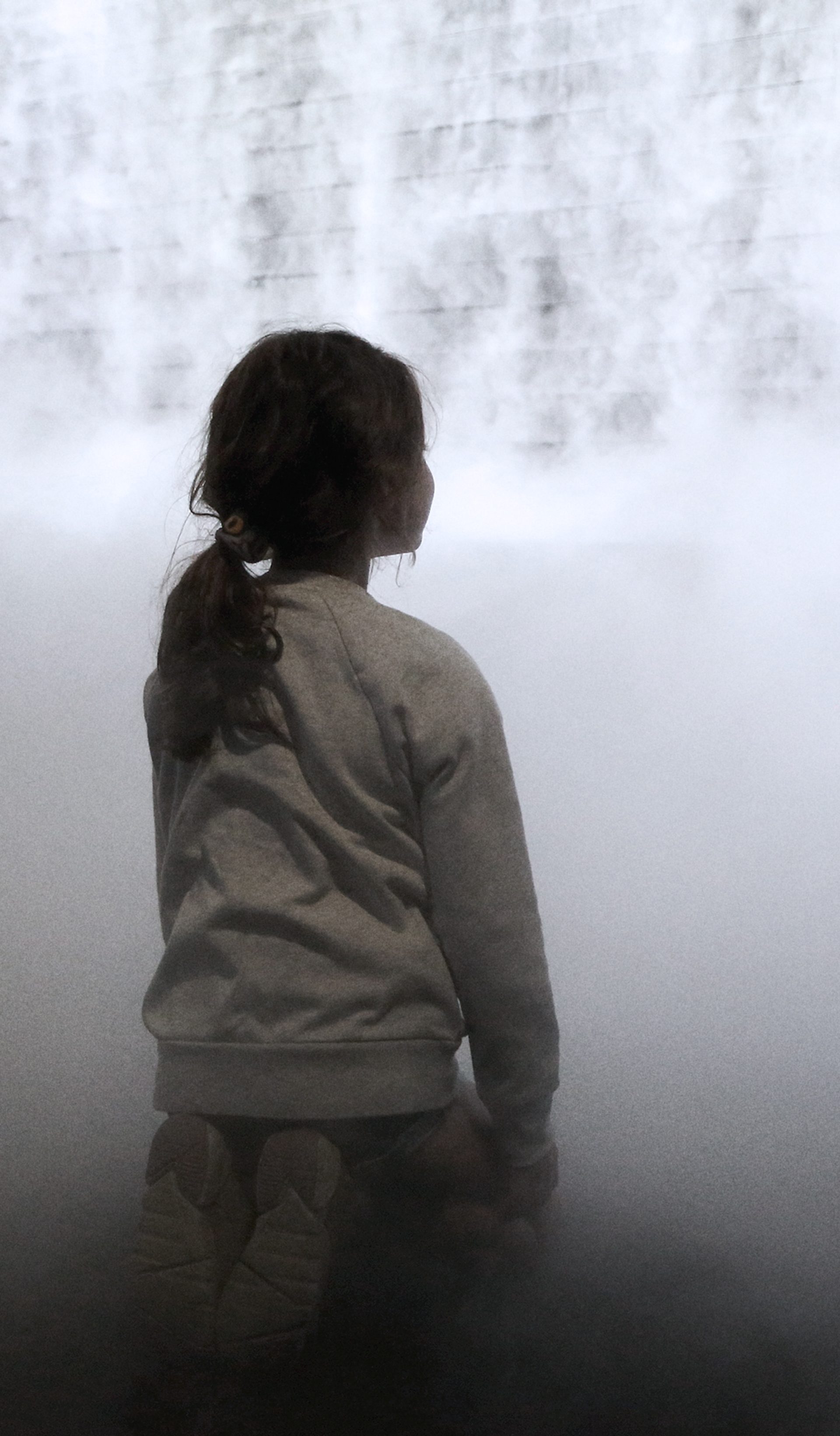 Little girl in front of cloud display, wall of smoke simulating cloud vapour