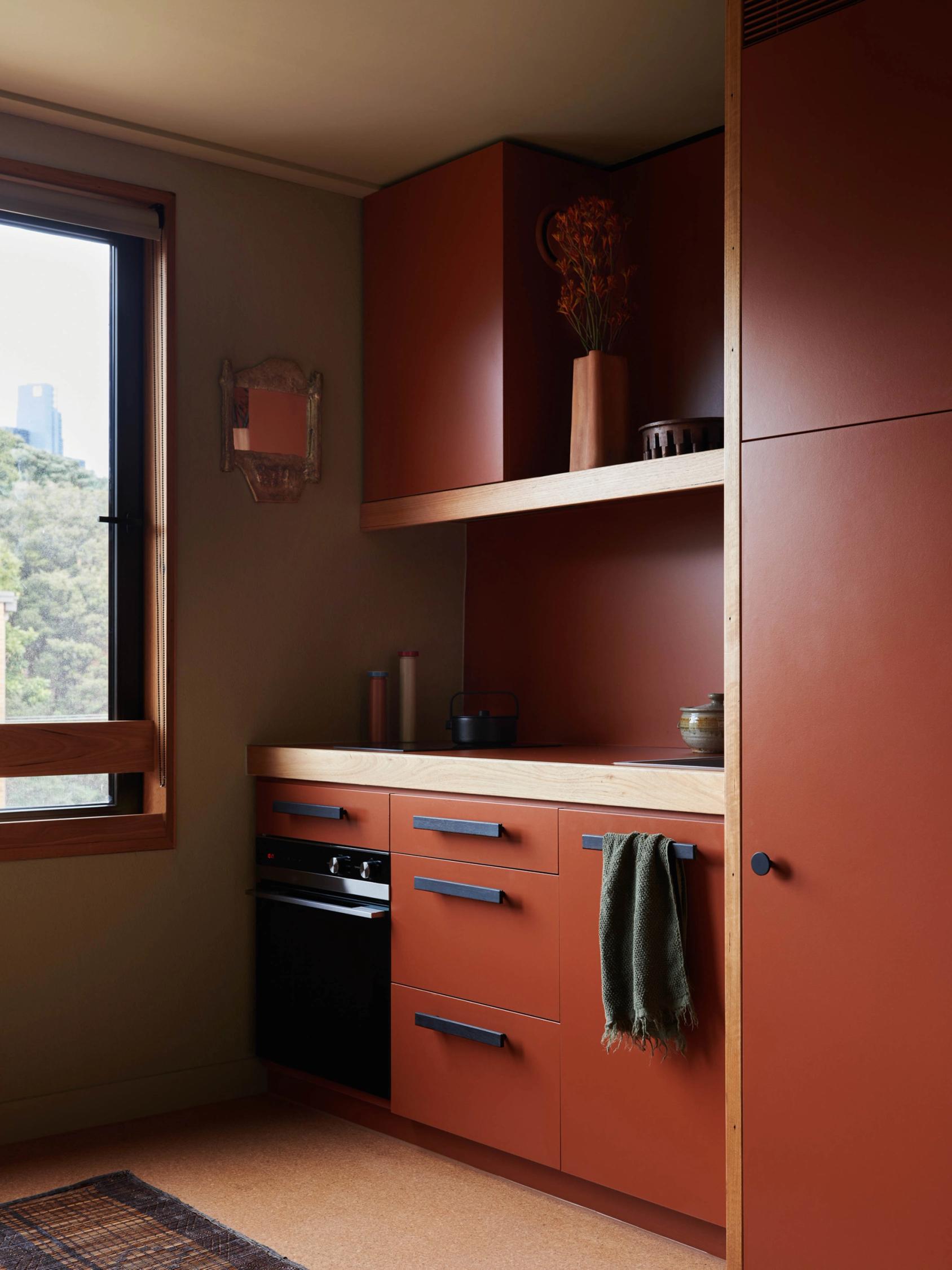 Maroon kitchenette with geometric fittings.