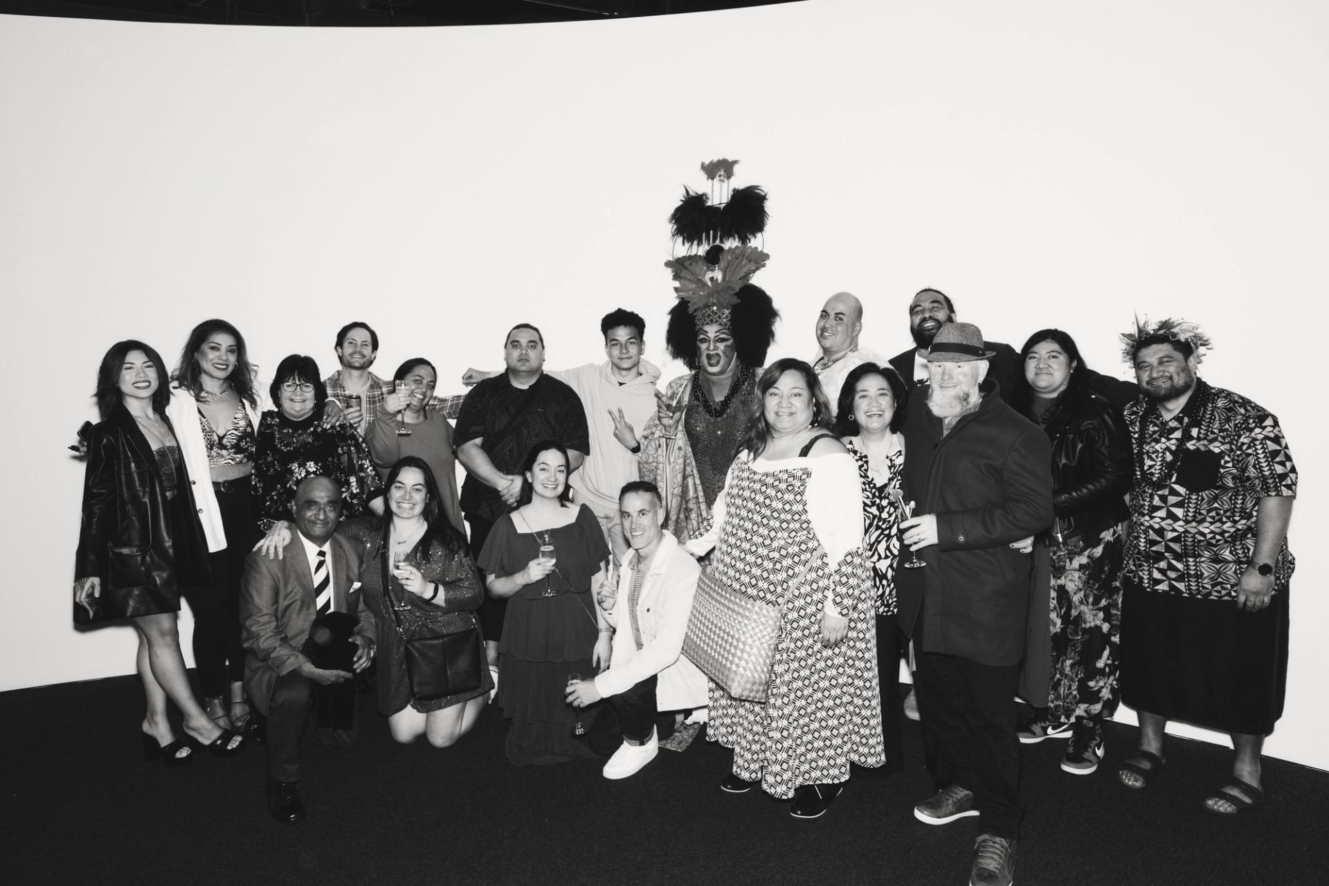 A large group of people posing in front of a white wall at the Powerhouse Museum, Ultimo.