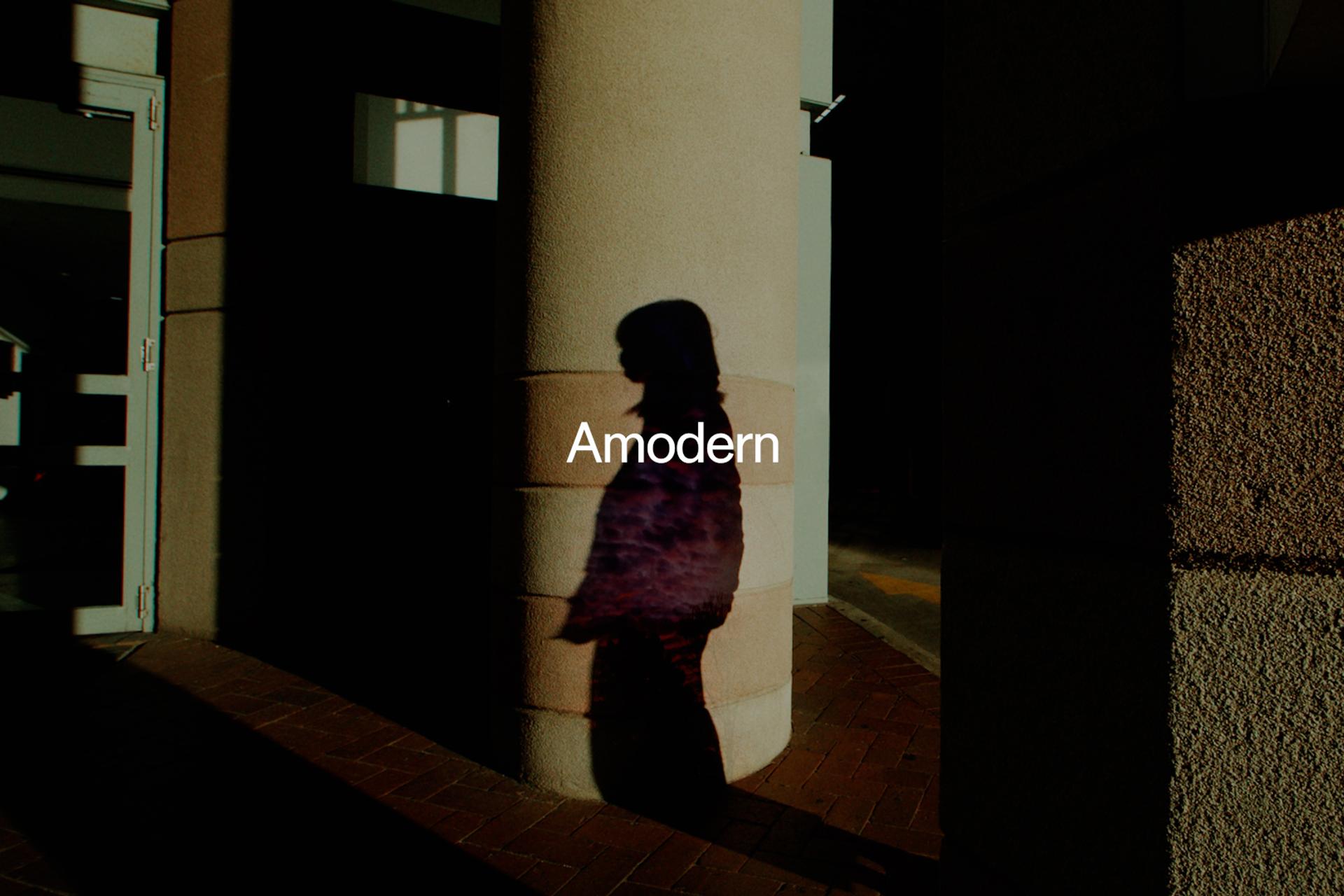 'Amodern' sits above a shadow of a figure amongst pillars of a building