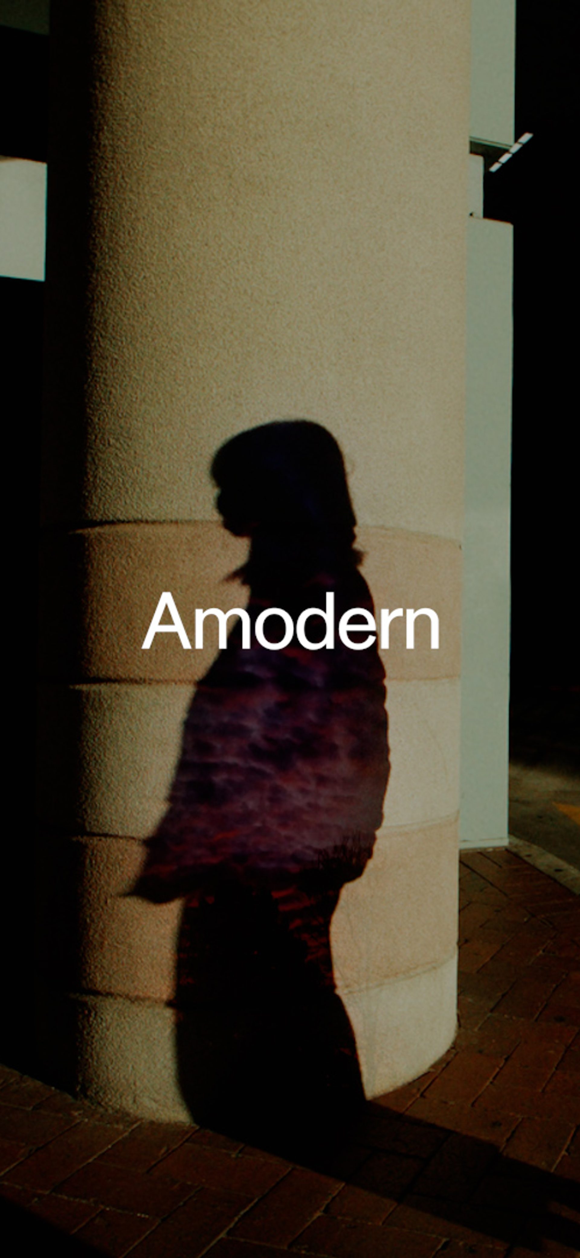 'Amodern' sits above a shadow of a figure amongst pillars of a building