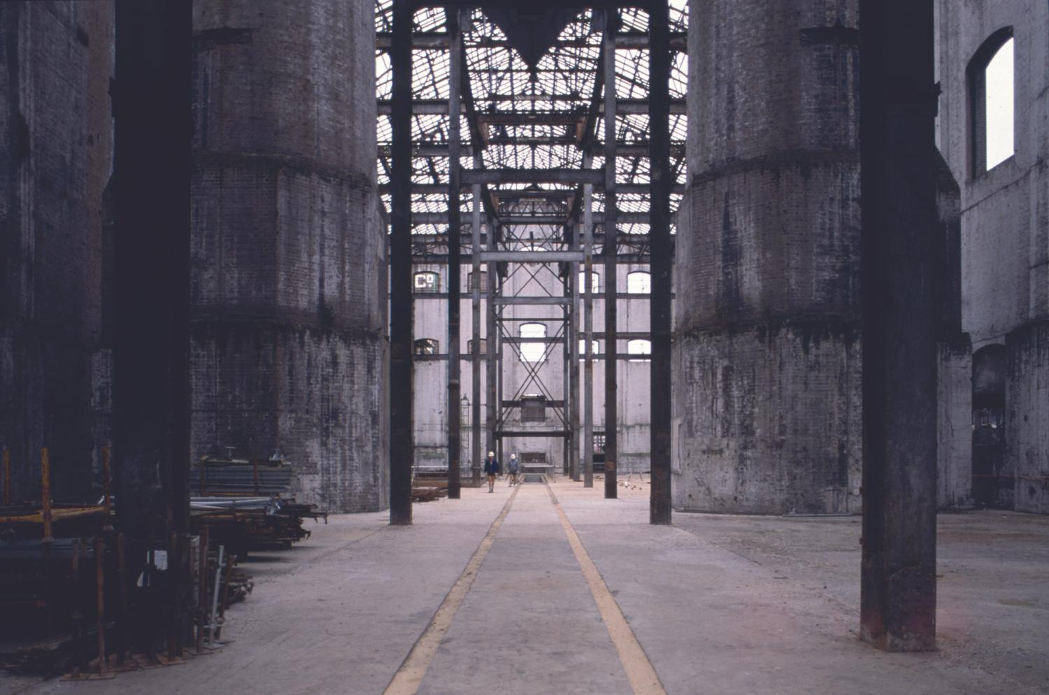 Photograph of gutted power station with two large chimney bases flanking each side of the image