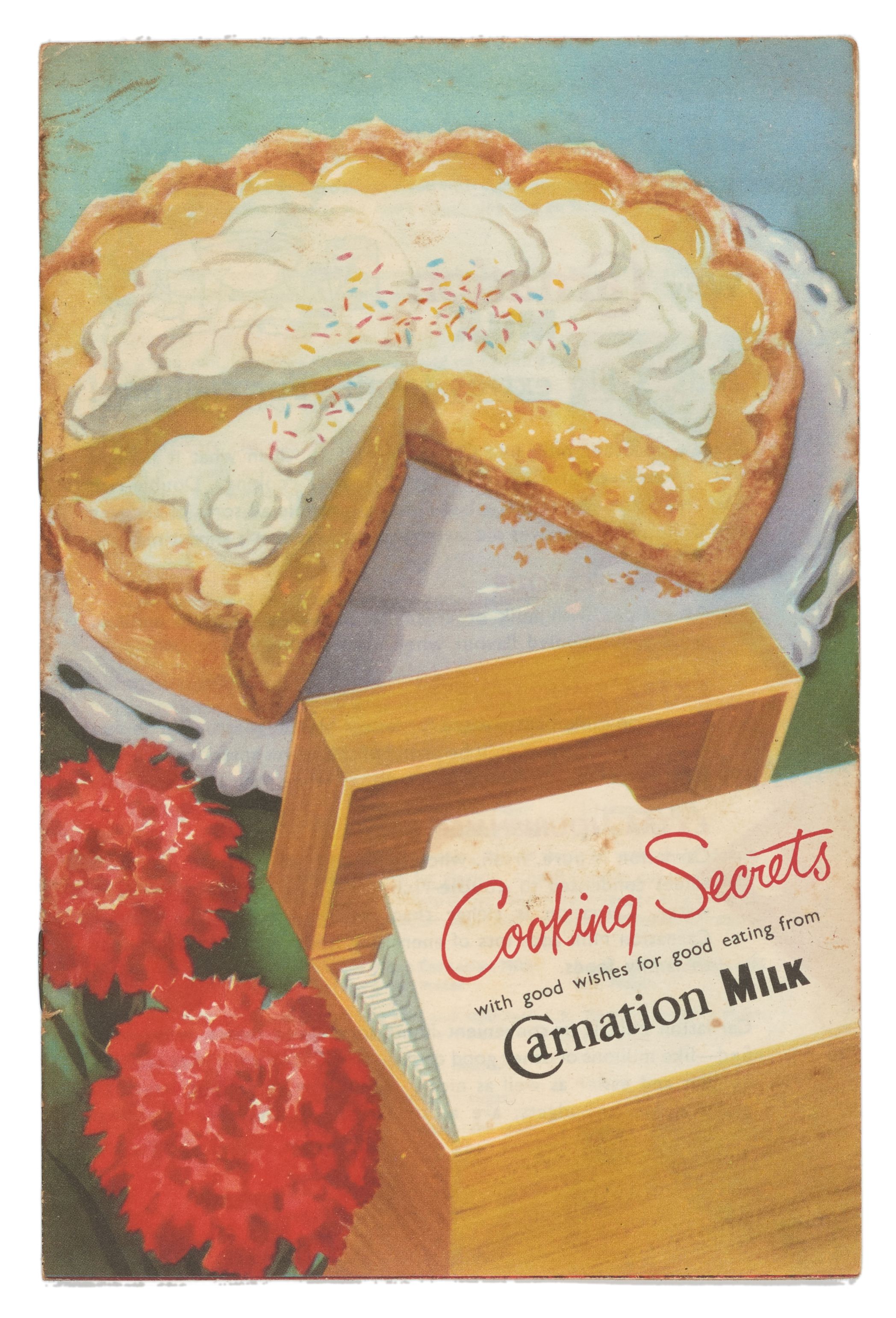 Illustration of a custard pie on a table with a box of recipe cards displaying the note, ‘Cooking Secrets with good wishes for good eating from Carnation Milk.’