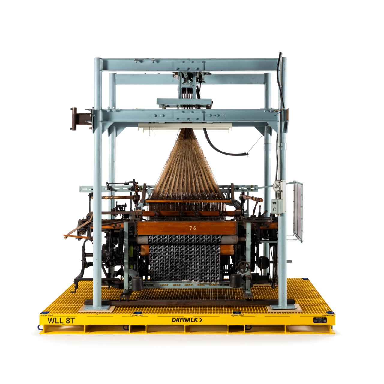 Box shuttle overpick loom with Jacquard & harness. Supported in steel frame & driven through a belt drive by a CMG 415V 3phase electric motor. All metal, timber and leather components and finishes appear to be in good condition.