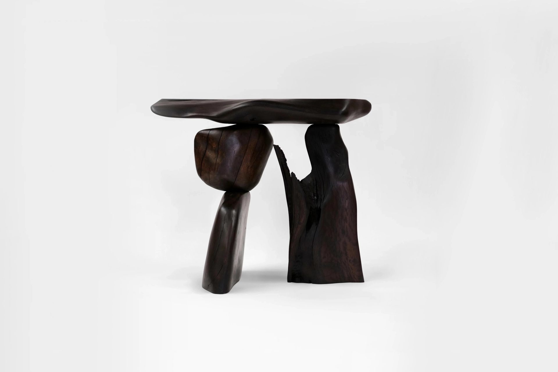 Dark wooden pieces combined to make a table looking artwork