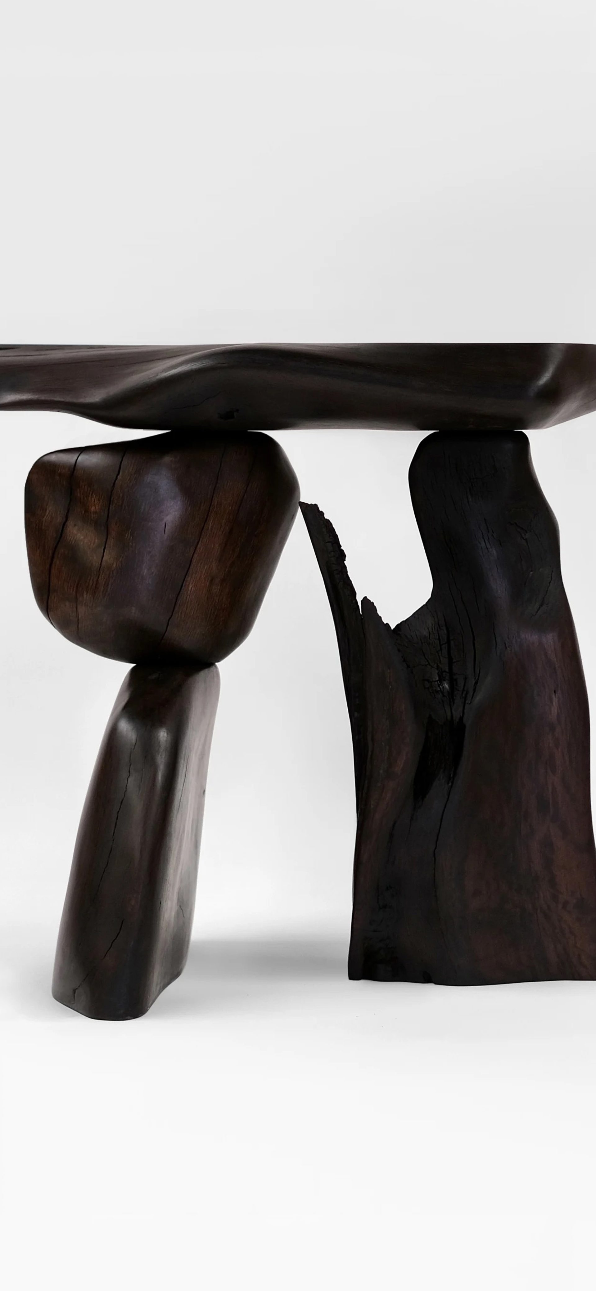 Dark wooden pieces combined to make a table looking artwork