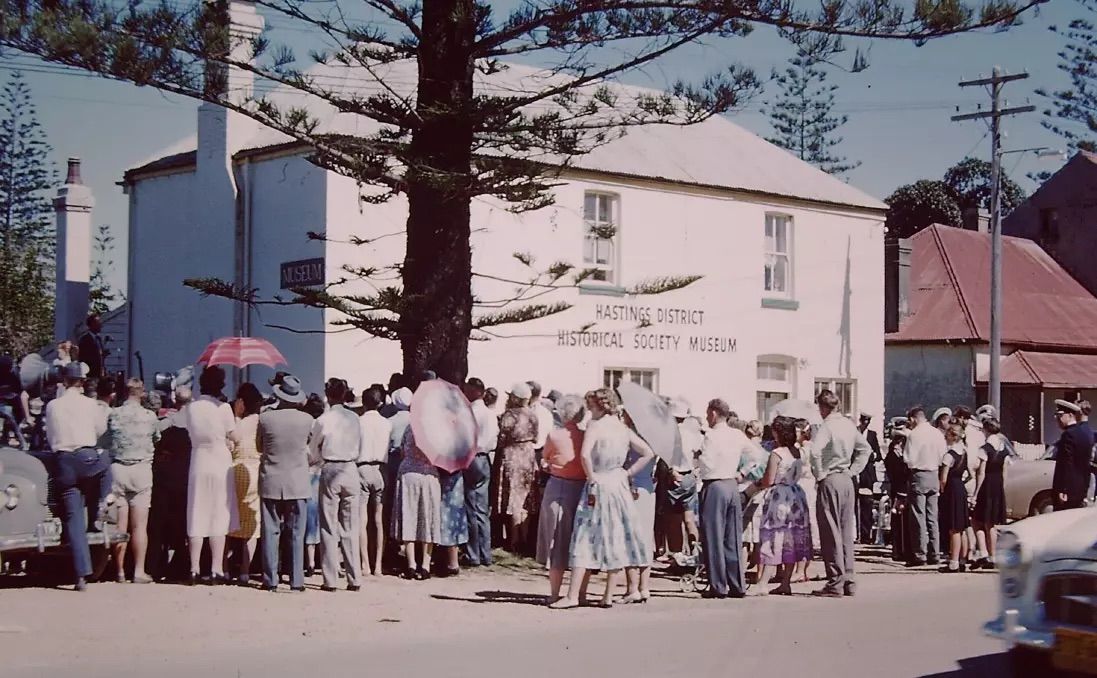 People gathering on a road, to the opening of a museum.