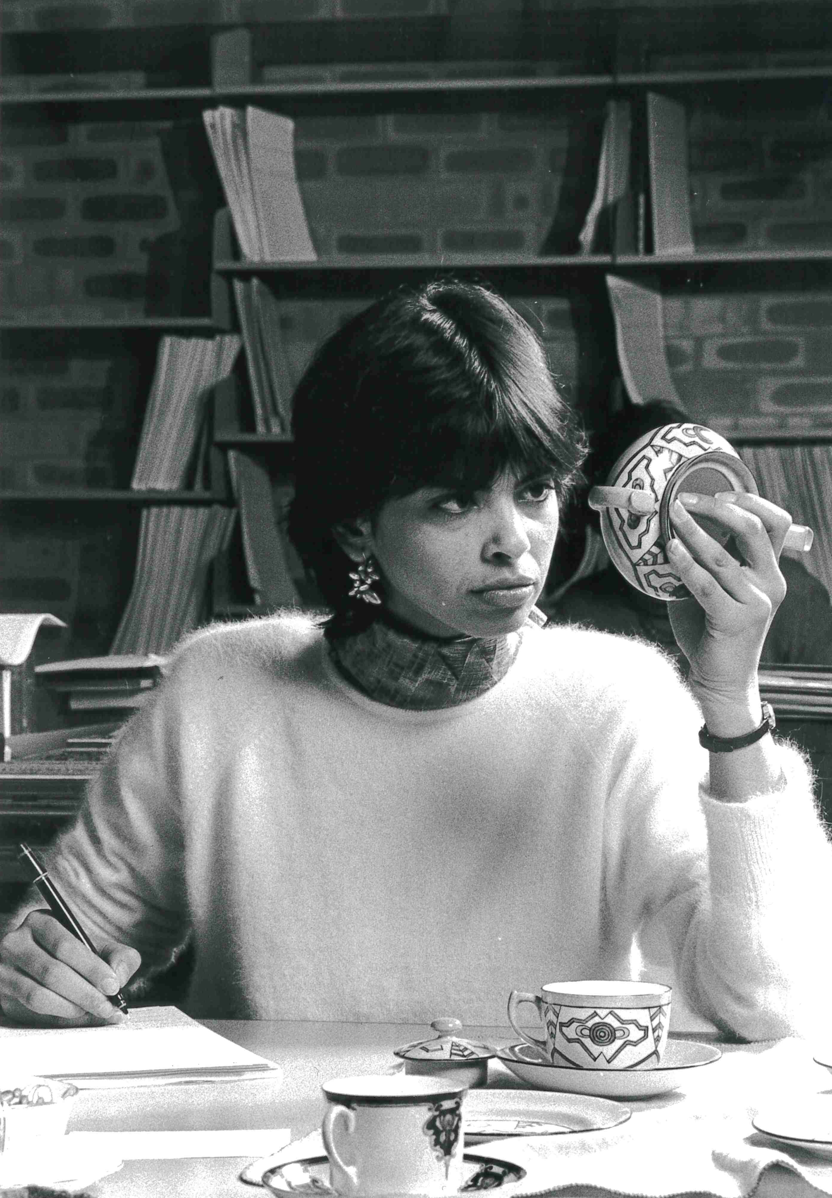 Black and white image of a museum conservator inspecting ceramics