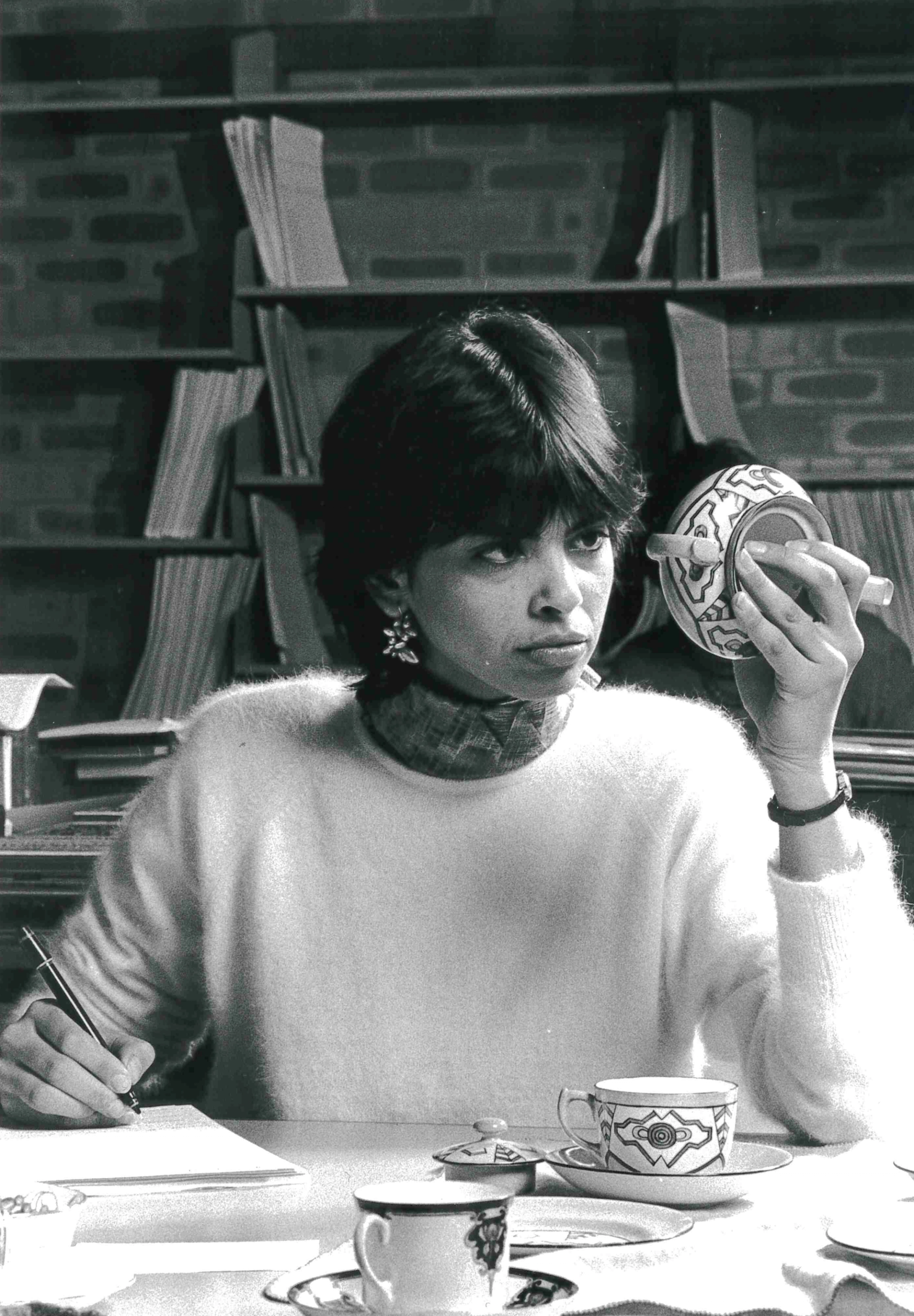 Black and white image of a museum conservator inspecting ceramics