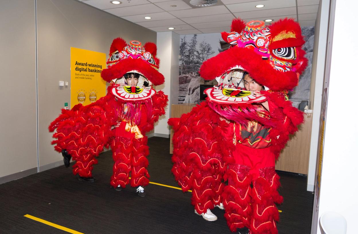 Two Lunar New Year lions perform in the foyer of a building.