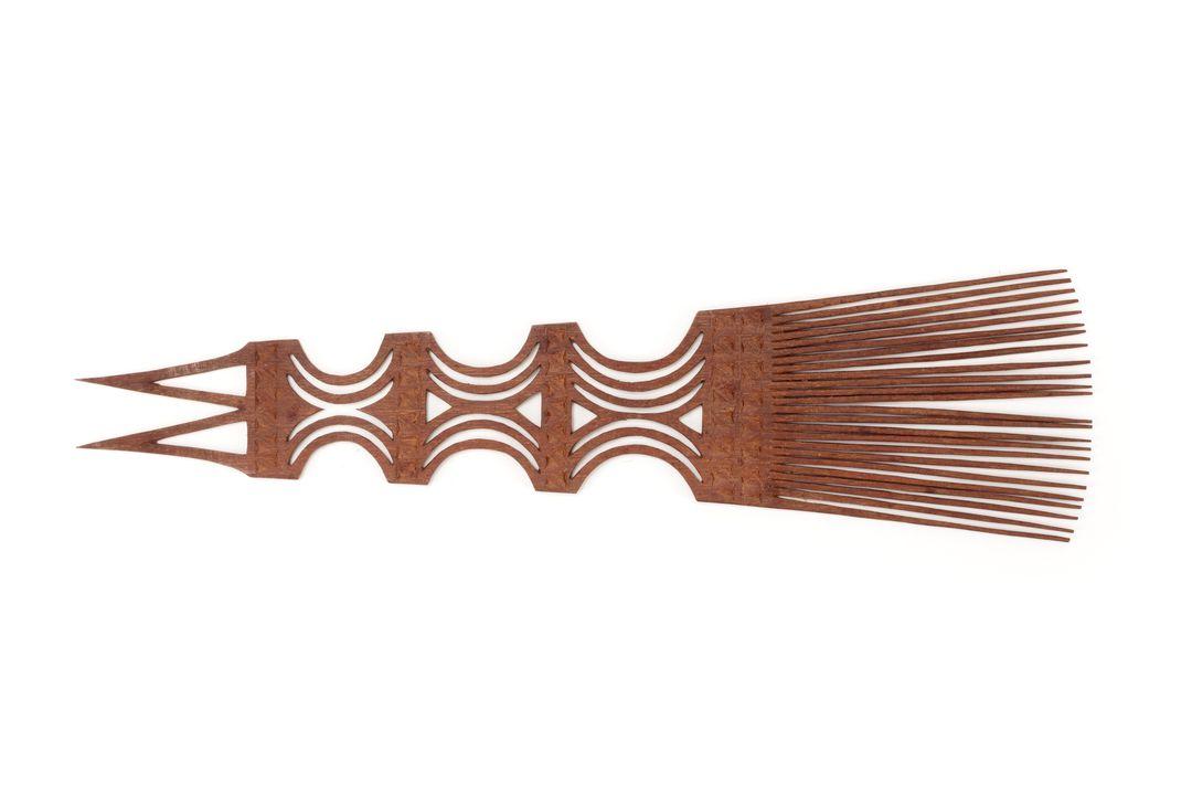 Carved wooden comb made in Samoa, featuring an intricate fretwork pattern and 24 teeth.