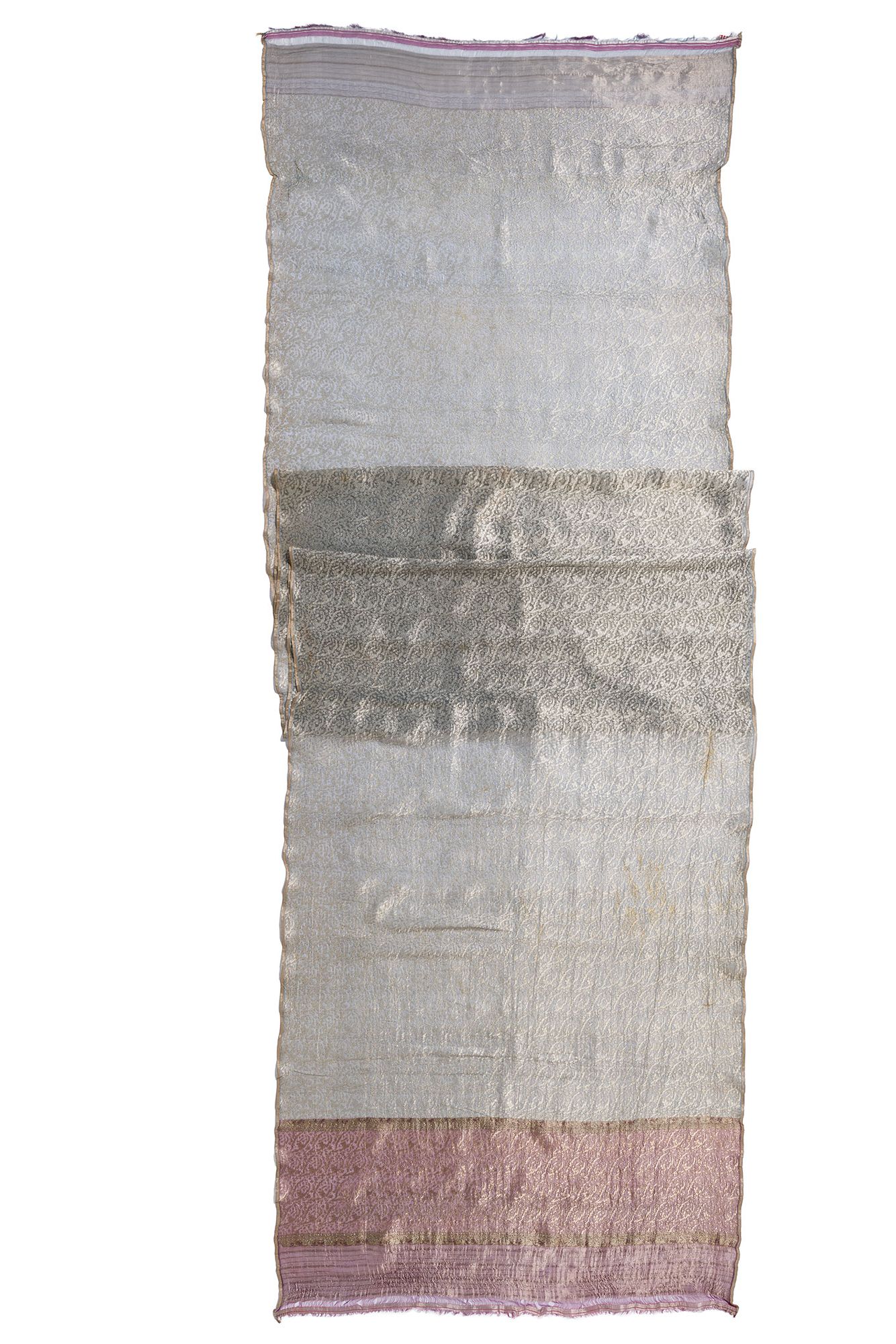Sari length whose body and end border are decorated with an offset repeat design of serrated leaves and tiny flowers. The warp for the body is of fine light blue silk, which changes to magenta for the border; the selvedge warps are of gold-wrapped thread.