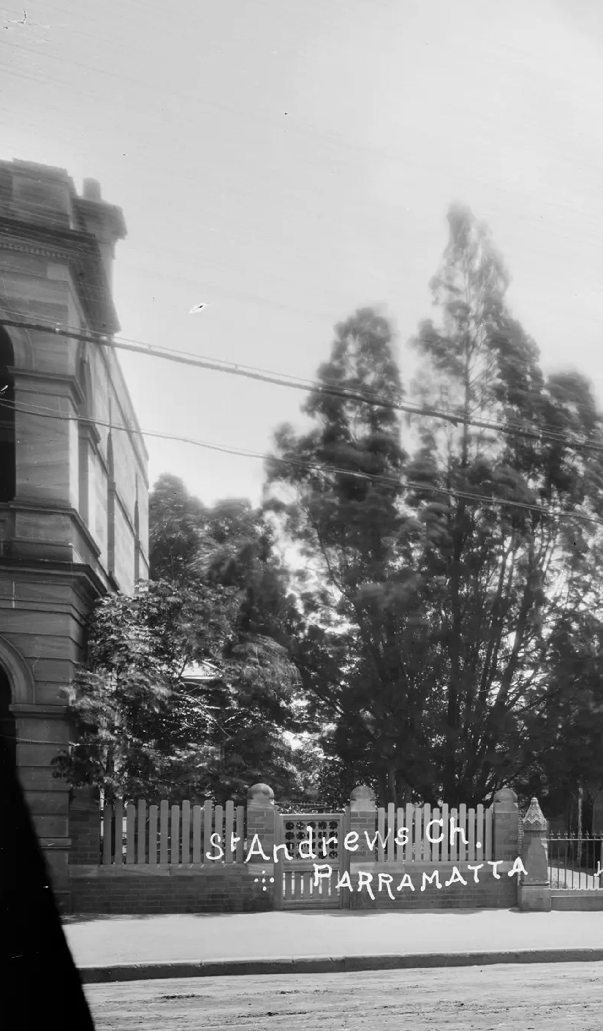 Silver gelatin dry plate glass negative in landscape format. The image depicts St Andrews Presbyterian Church in Parramatta. The church is depicted in the centre of the image. The front of the church features a turret like tower with four spires. The electric tramway is depicted in the foreground of the image. Other buildings are partially depicted on either side of the church. A hansom cab can be seen in the foreground in the left side of the image. The caption, studio mark and studio number are inscribed on the reverse of the negative.