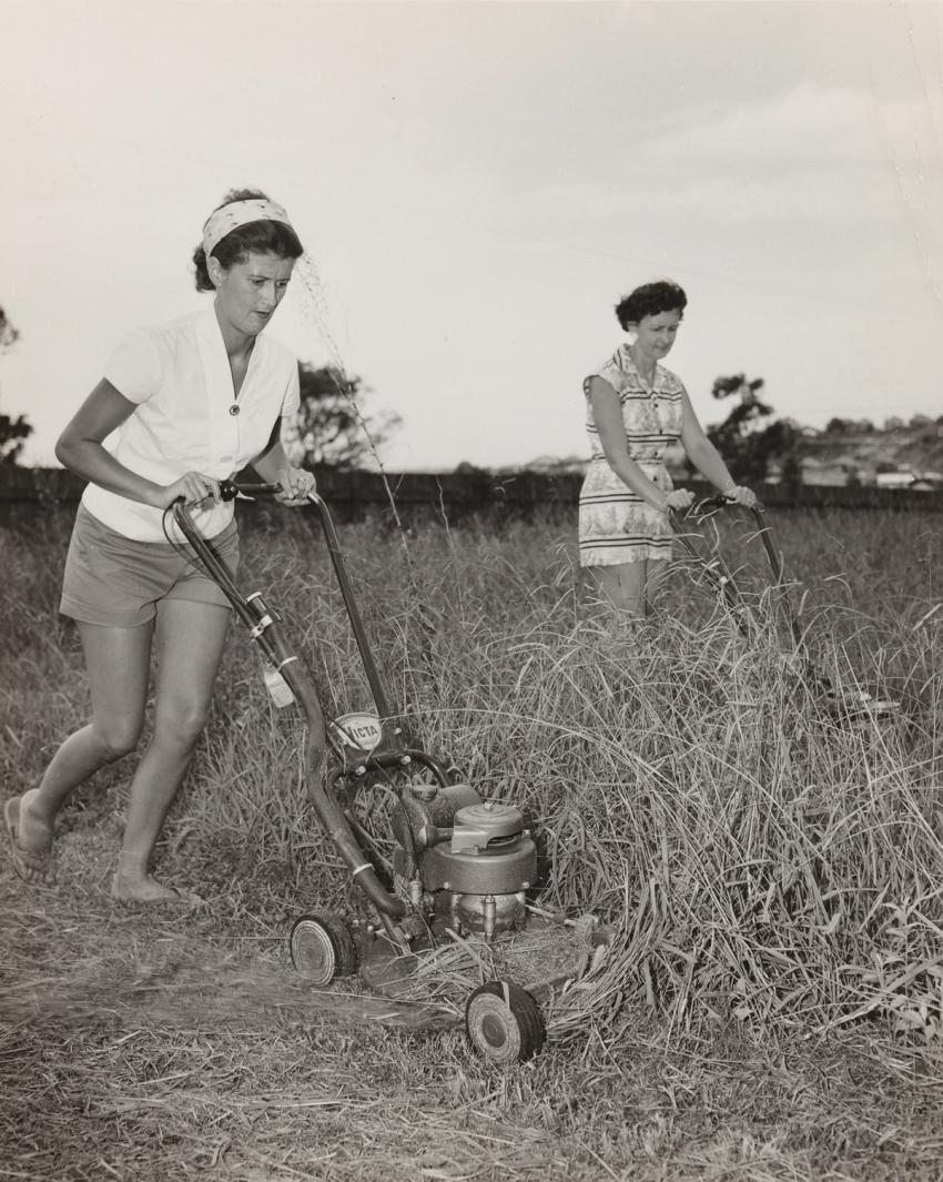Two 1950s women mowing grass