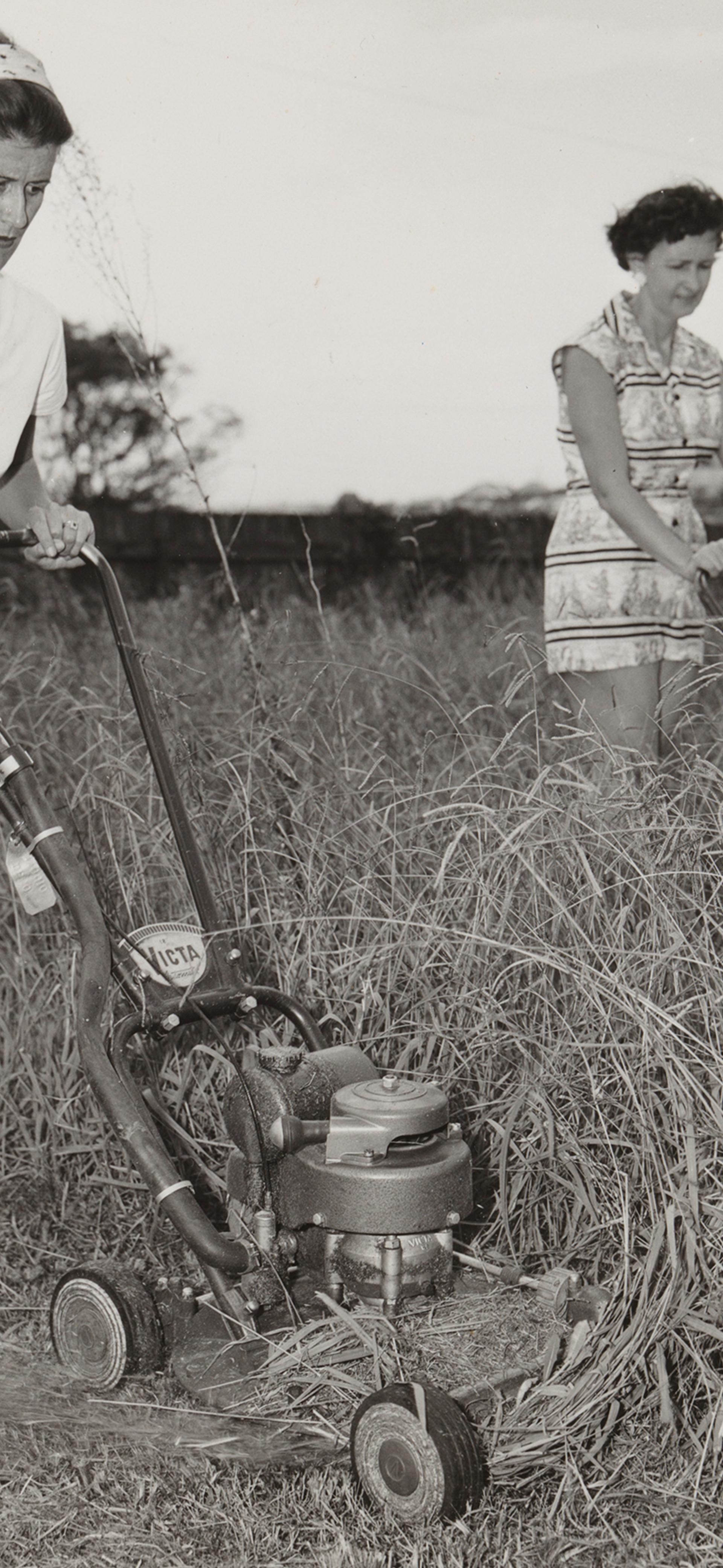 Two 1950s women mowing grass