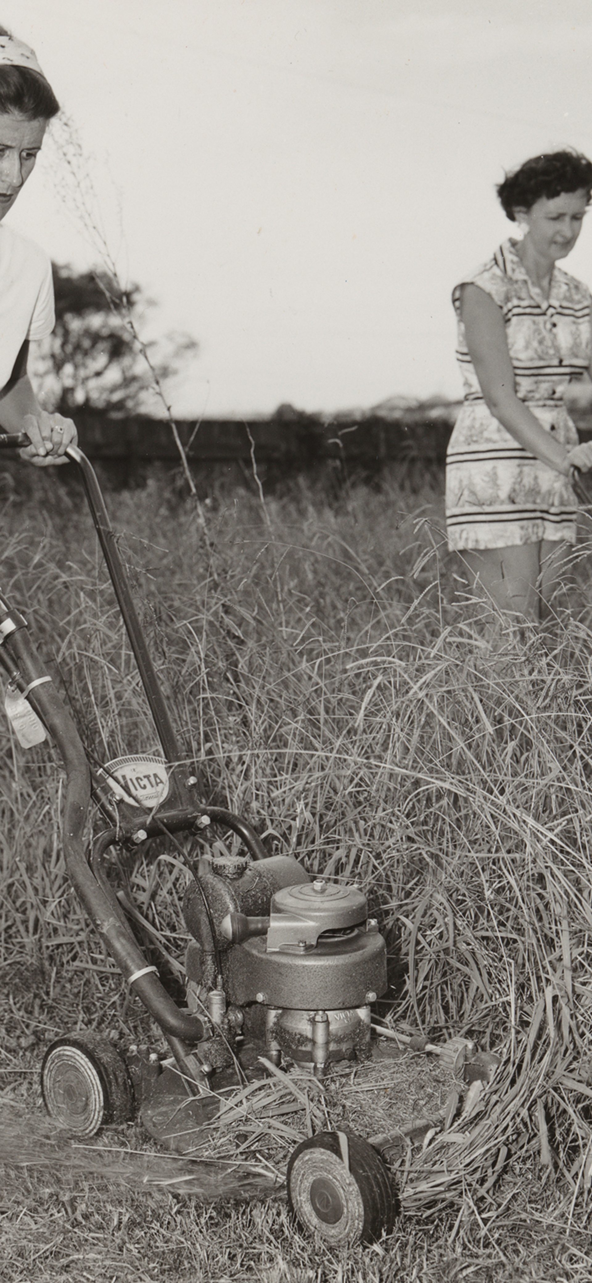 Two 1950s women mowing grass
