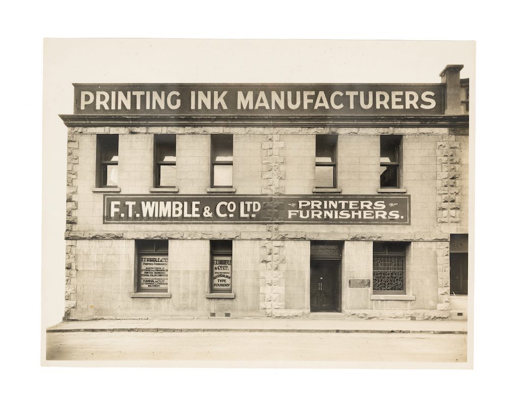 Sepia photograph depicting a sandstone brick office building.