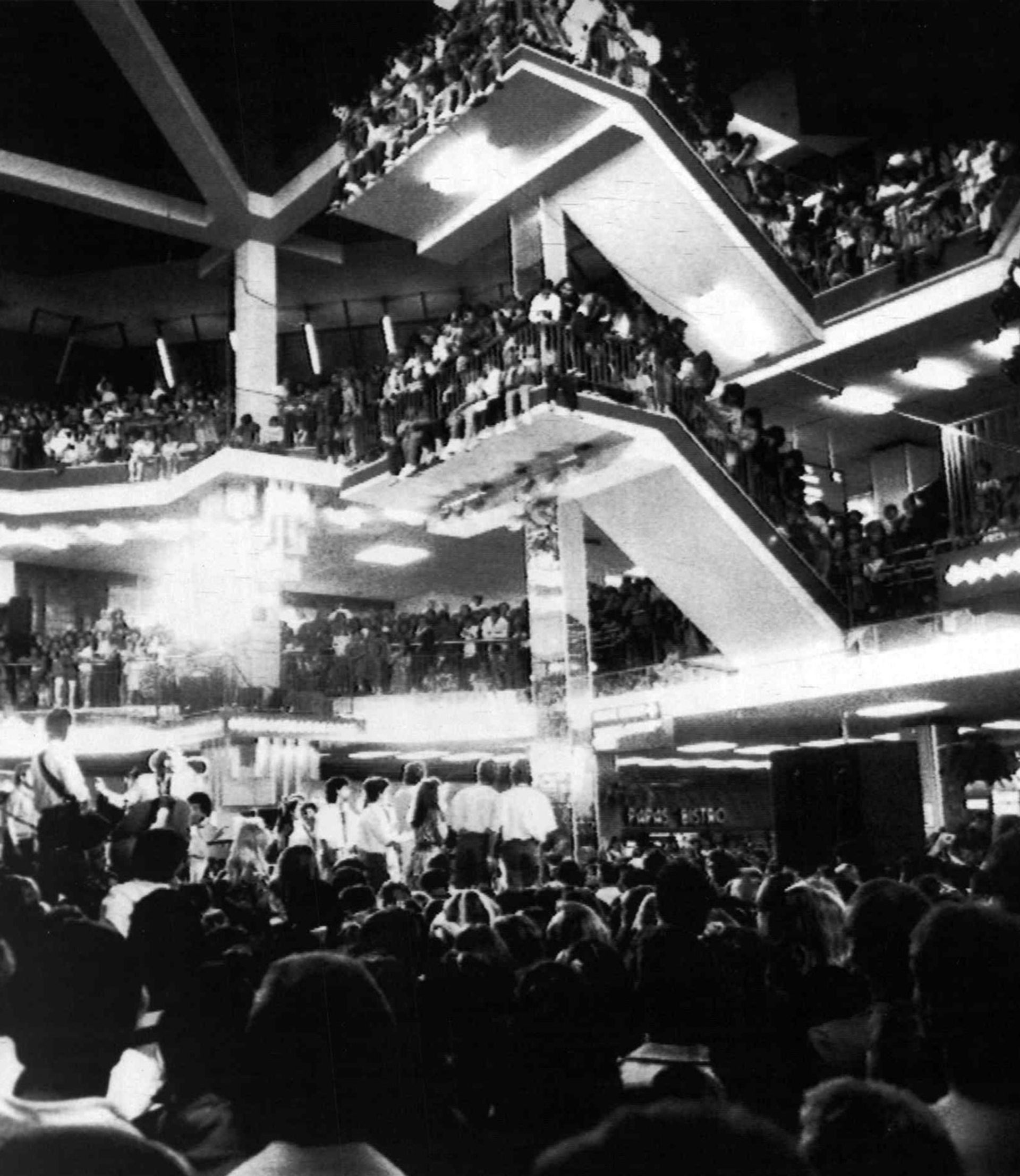 A photograph of a crowded Parramatta Westfield mall, audiences crowding around the floor and balcony looking towards the centre stage.