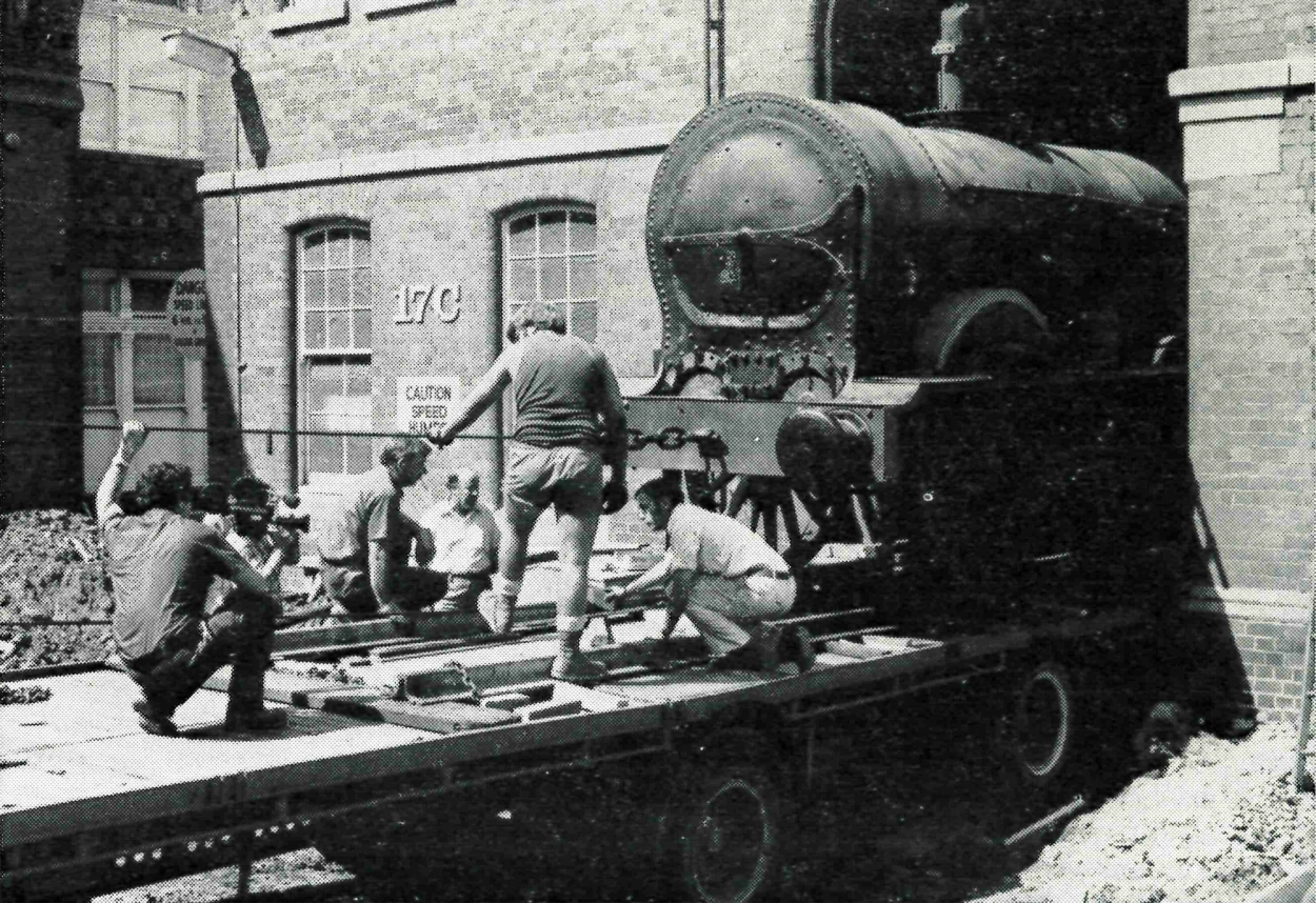 Black and white photograph of men moving a train