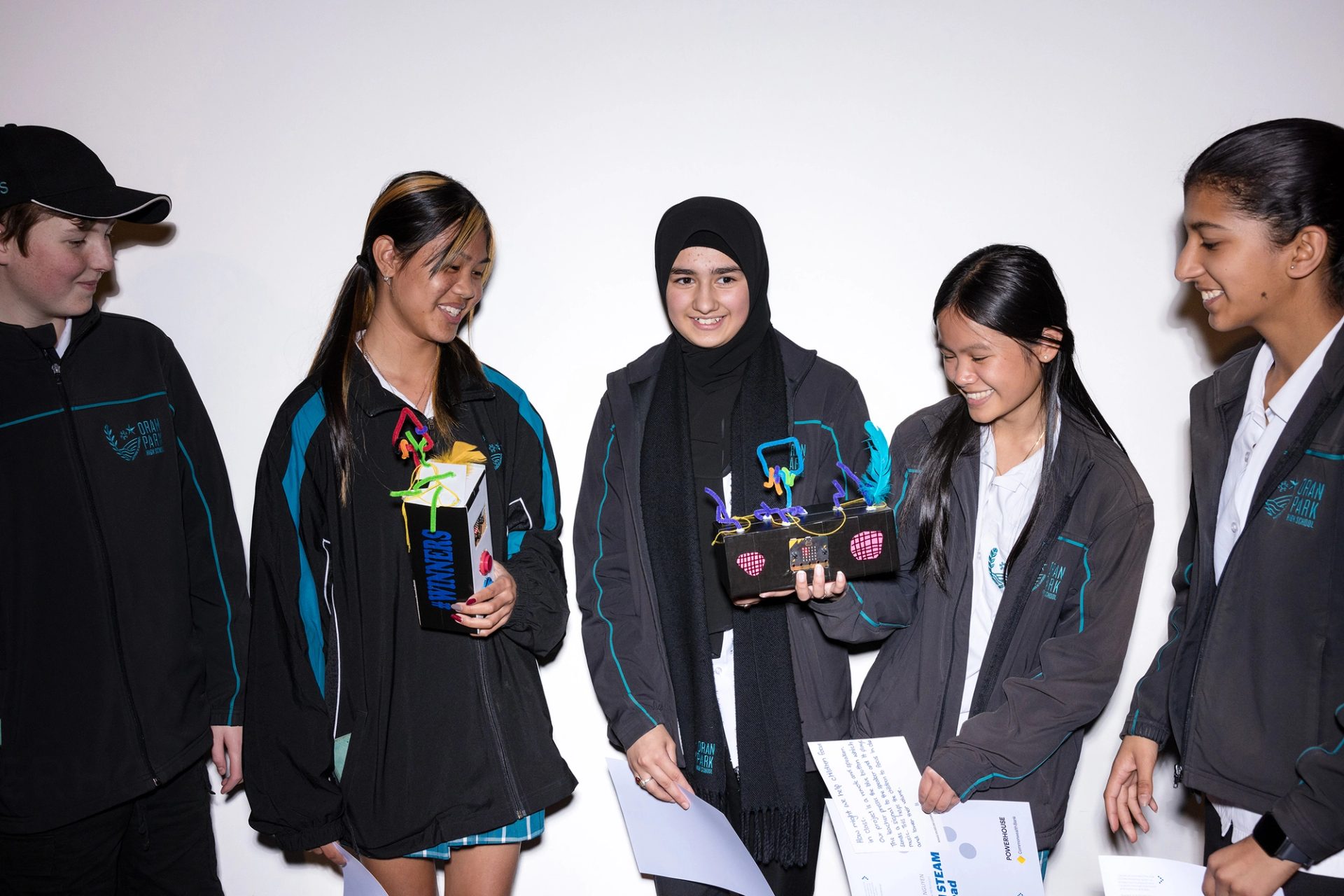 Five school children hold up their prototypes