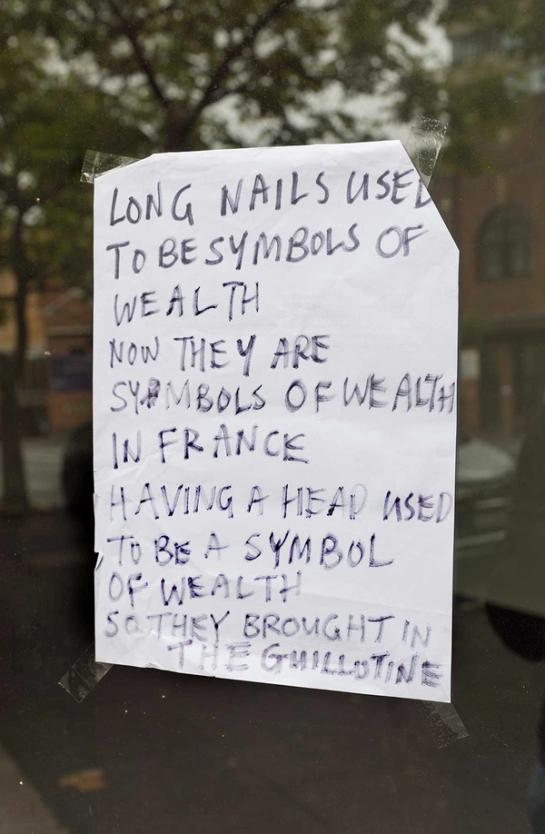 Note reading “LONG NAILS USED TO BE SYMBOLS OF WEALTH NOW THEY ARE SYMBOLS OF WEALTH IN FRANCE HAVING A HEAD USED TO BE A SYMBOL OF WEALTH SO THEY BROUGHT IN THE GUILLOTINE”