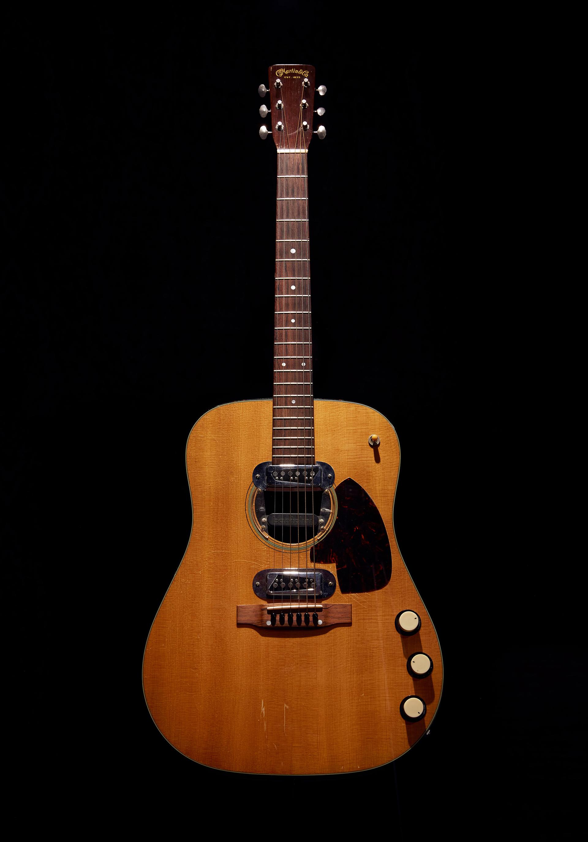An acoustic guitar against a black background.