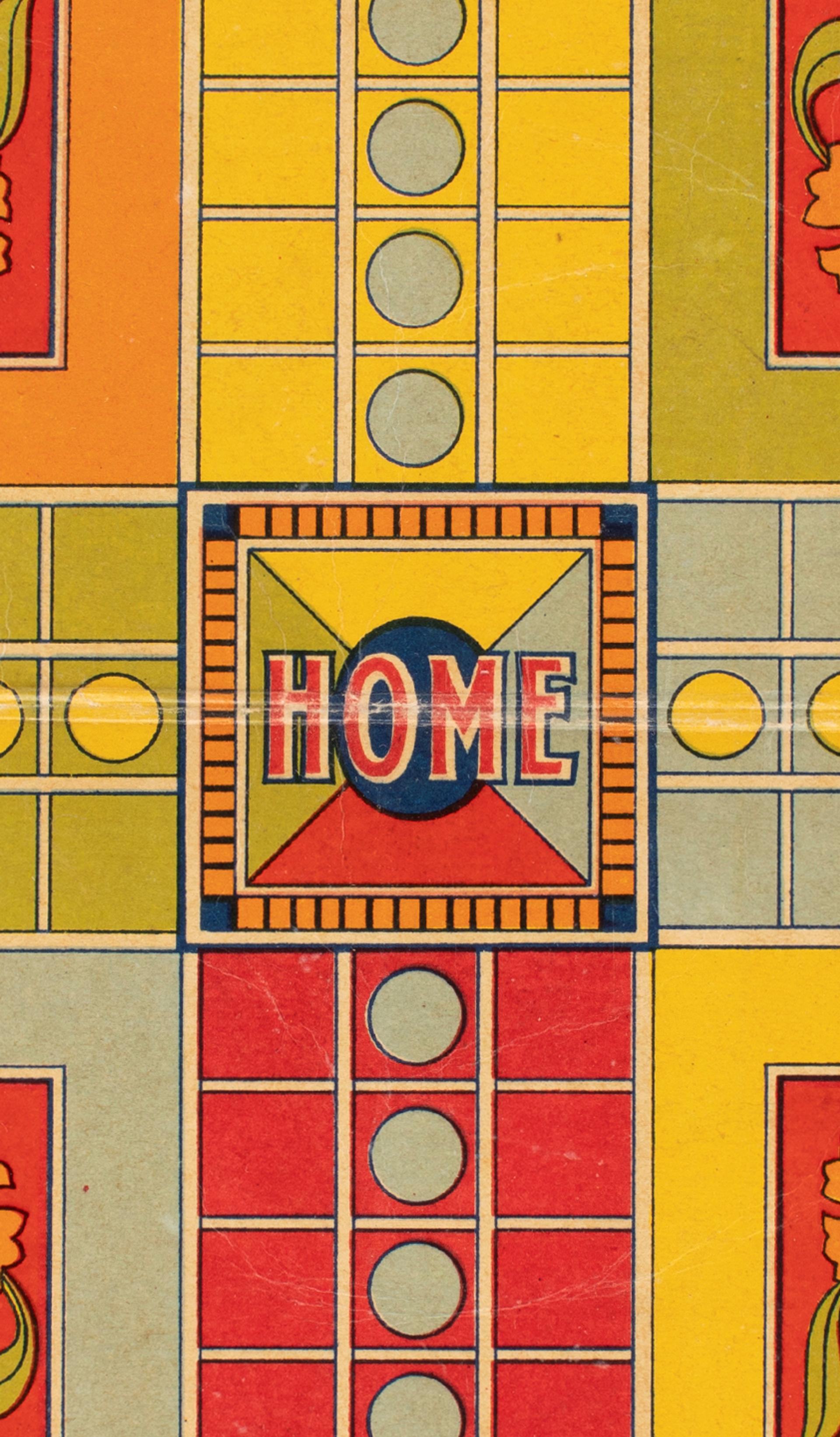 Close-up photograph of a red, yellow and green Ludo game board made of cardboard.