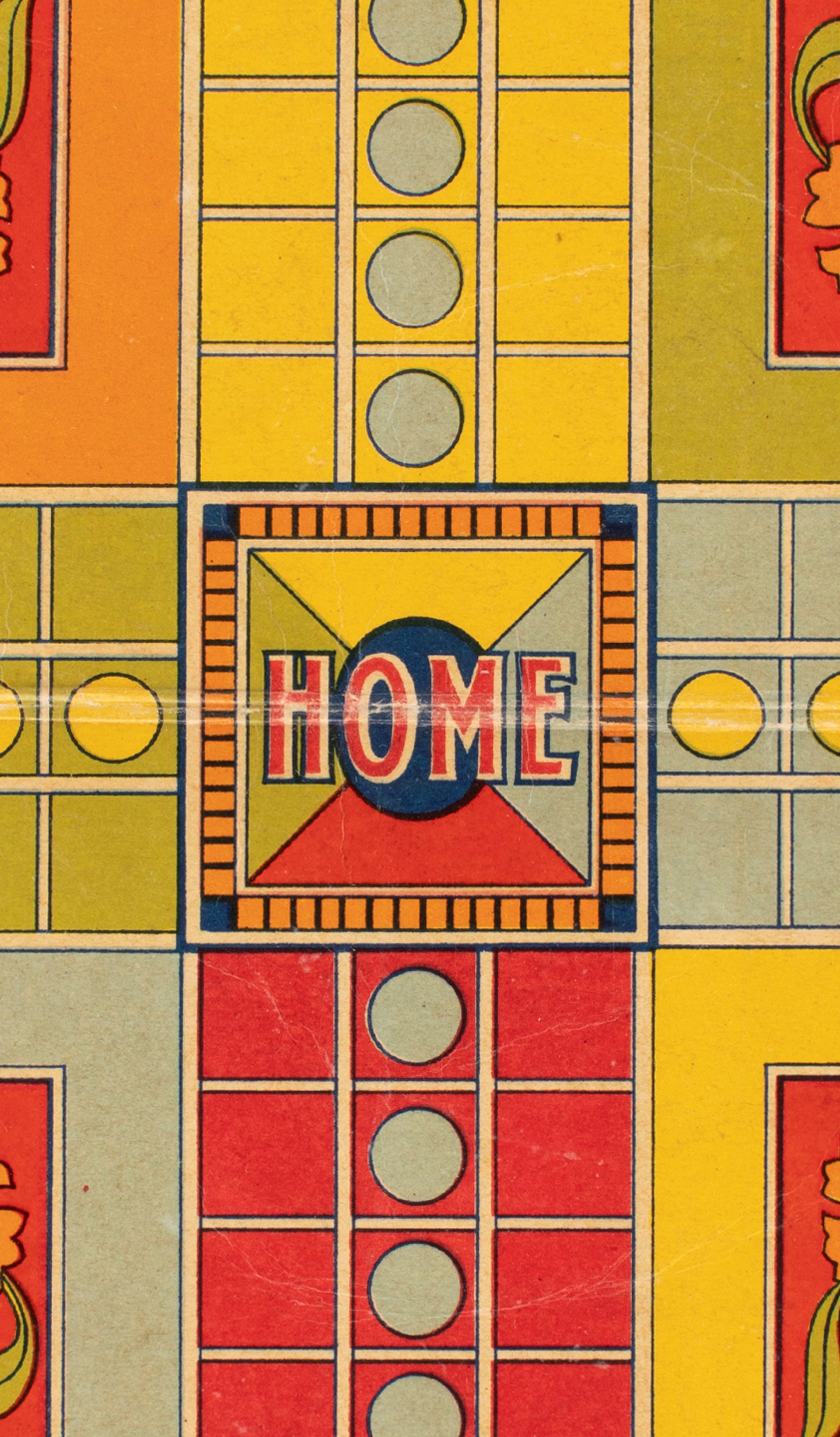 Close-up photograph of a red, yellow and green Ludo game board made of cardboard.