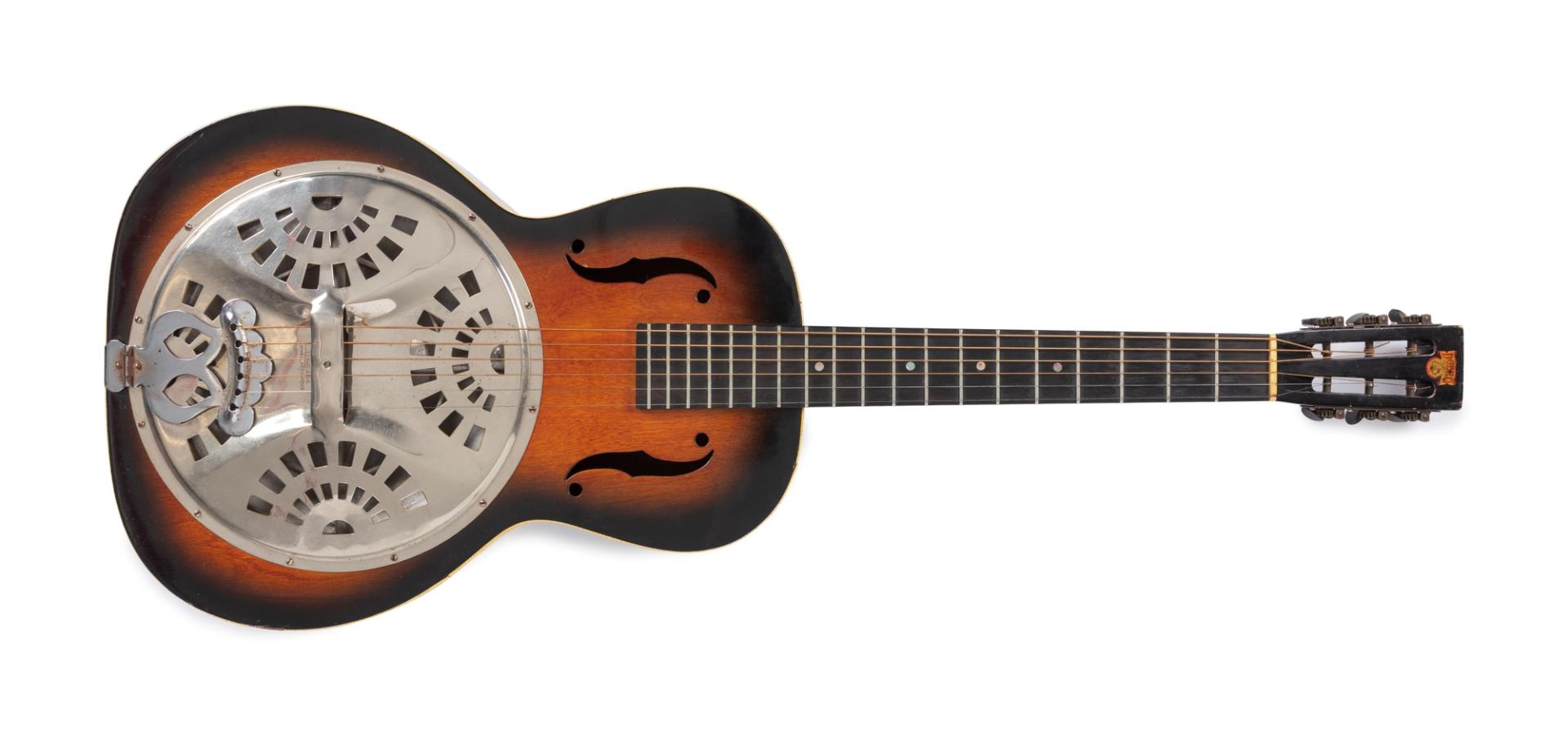 Sunburst varnished plywood body with aluminium resonator; celluloid binding front and back; 19 frets on stained rosewood fingerboard; six machineheads with black plastic pegs on a square topped slotted headstock carrying the Dobro transfer. No serial number on head. Eight armed spider bridge support. Standard coverplate pattern of 4 semi circular groups of rectangular holes with 17 holes in each group.
