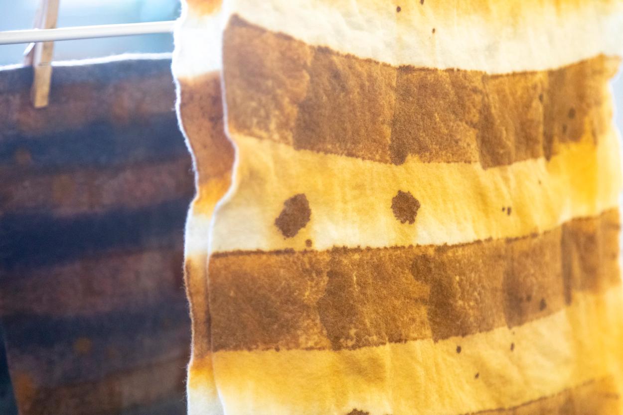 A close-up shot of a textile, dyed with a mustard-coloured pattern.
