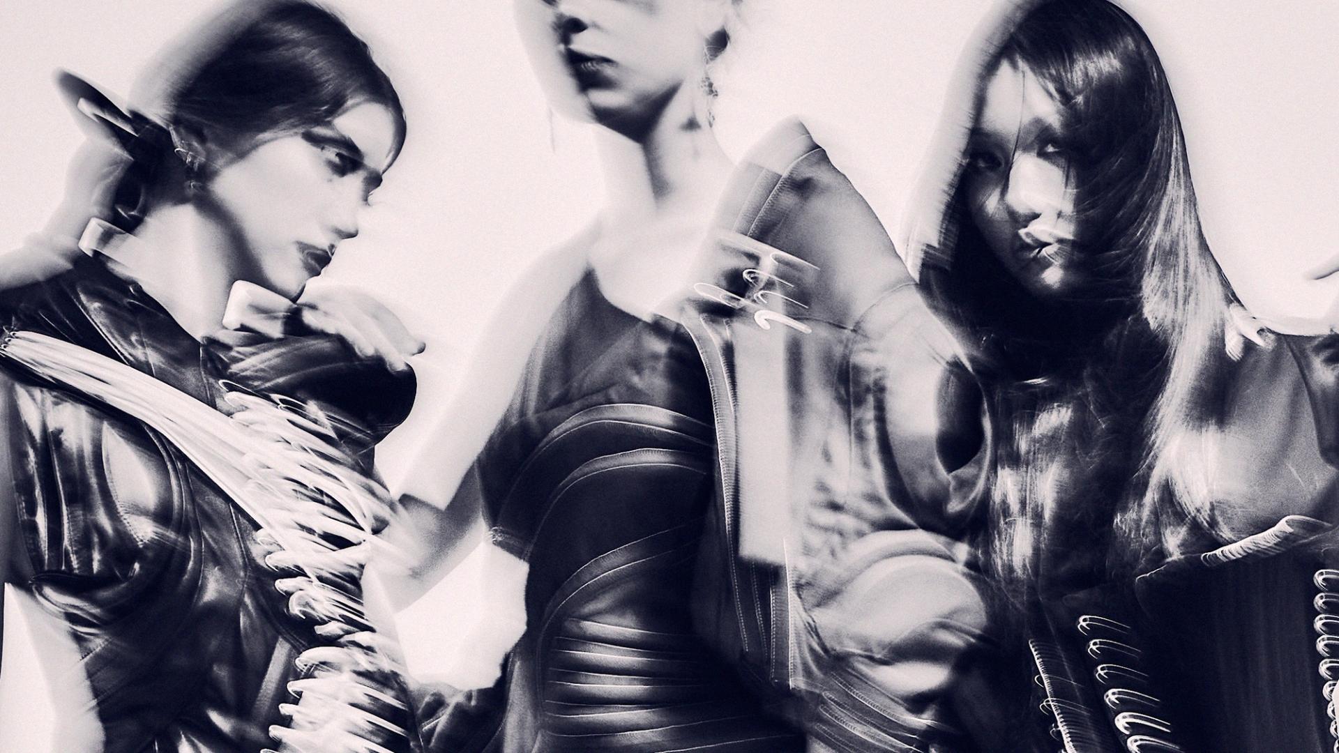 An abstract and hazy monochromatic image of three models.
