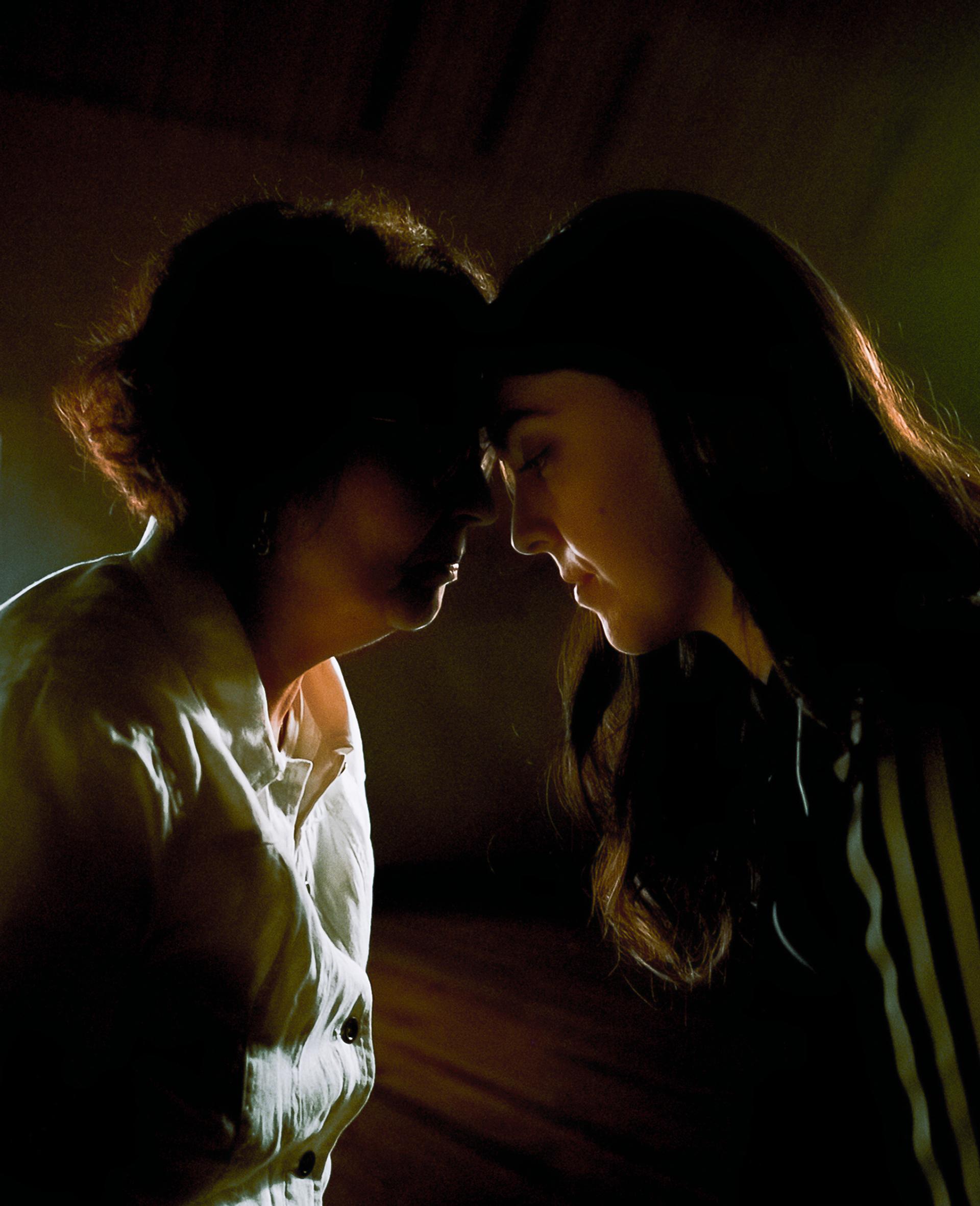 An older woman and a younger woman touch foreheads.