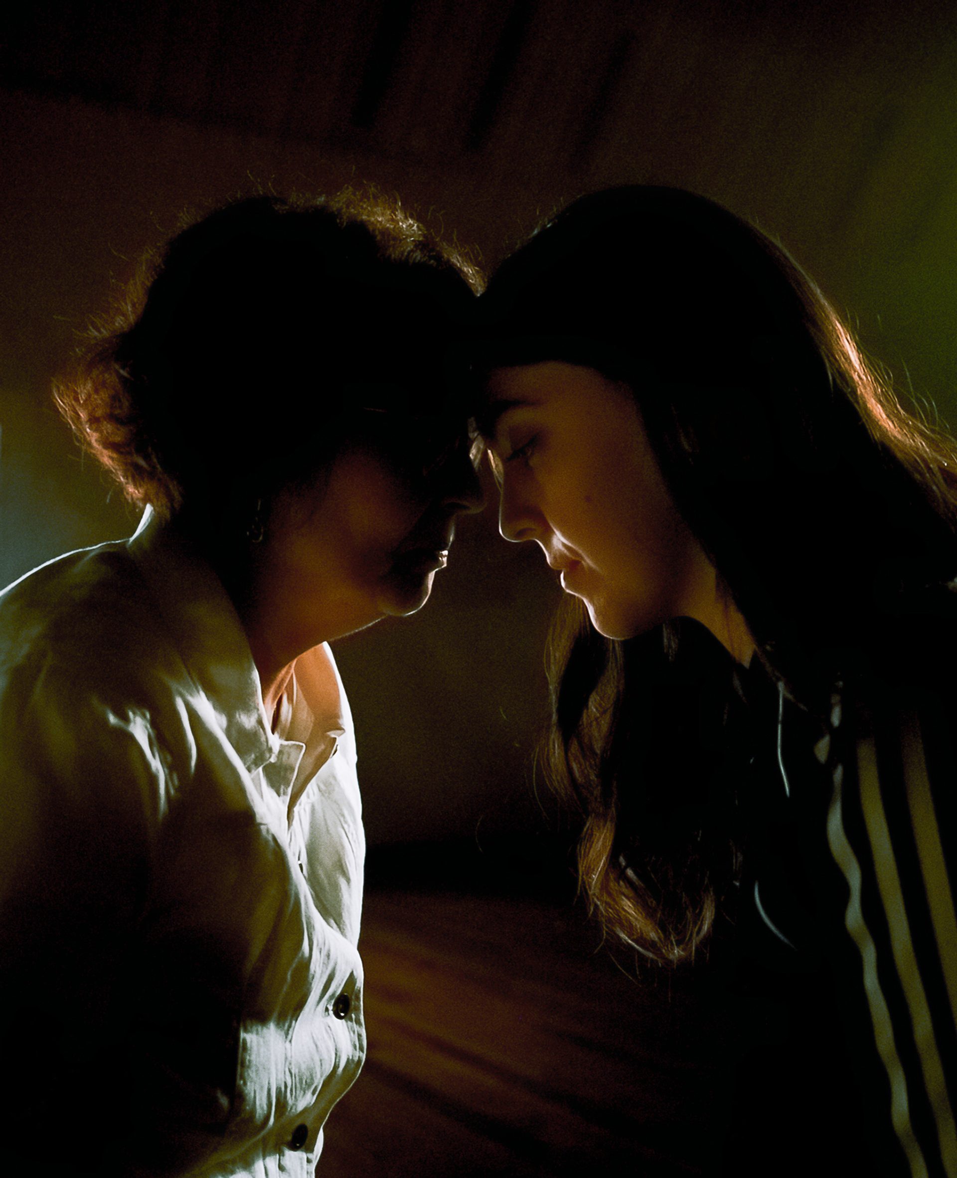 An older woman and a younger woman touch foreheads.