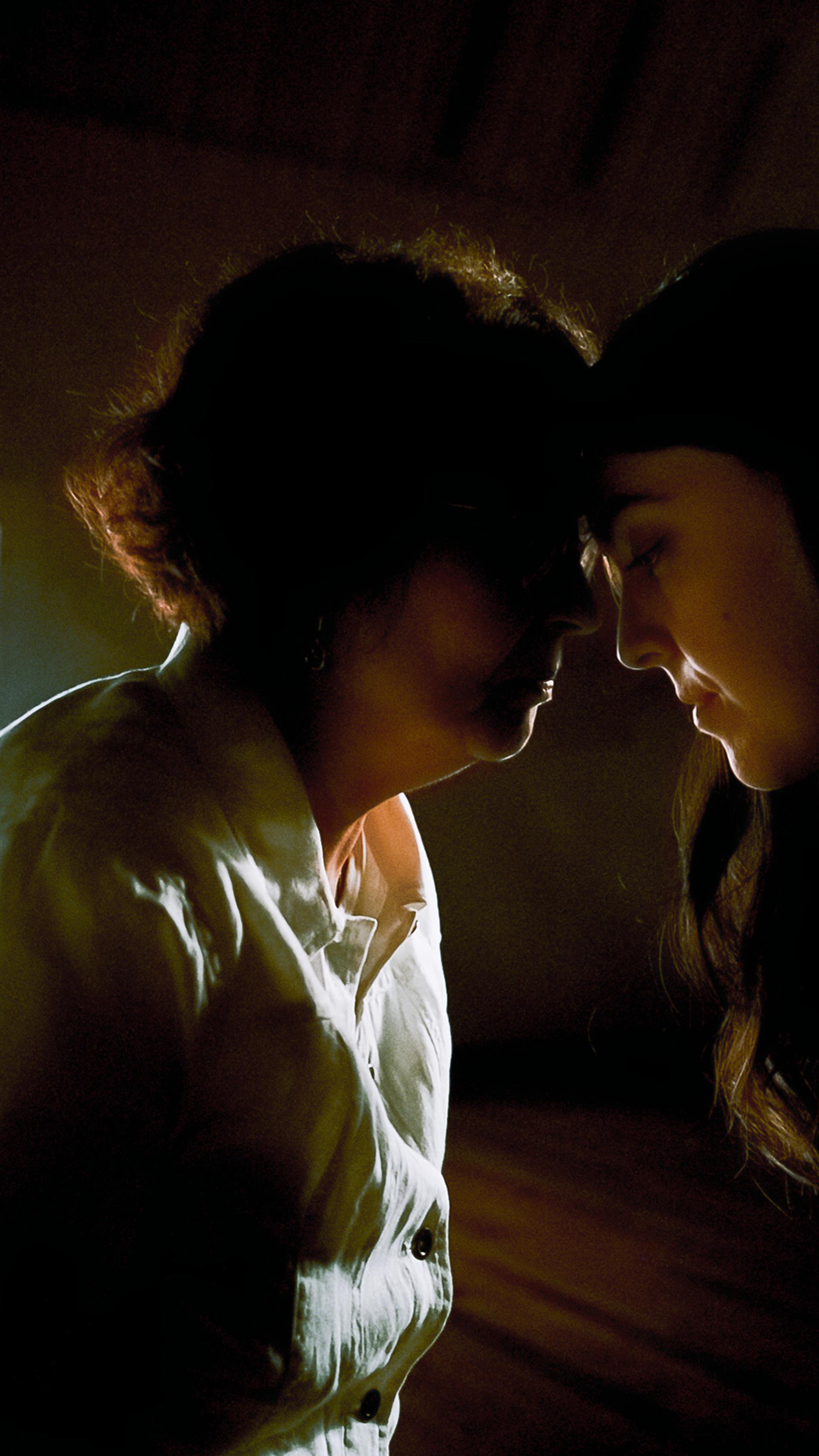 An older woman and a younger woman touch foreheads.