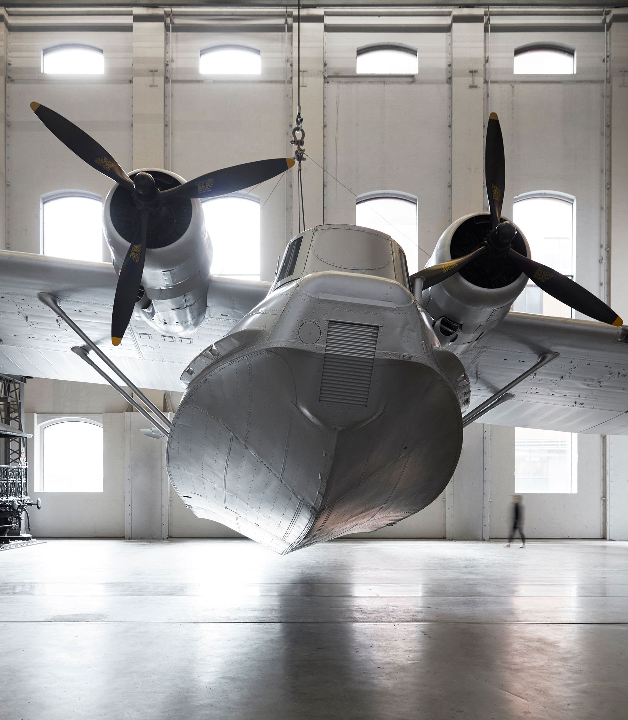 Front view of silver plane Catalina flying boat Frigate Bird II. The underside of the boat and two aircraft propellers are visible.