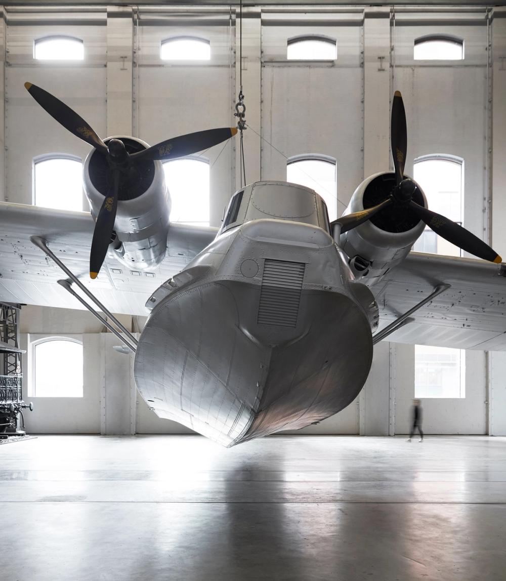 Front view of silver plane Catalina flying boat Frigate Bird II. The underside of the boat and two aircraft propellers are visible.