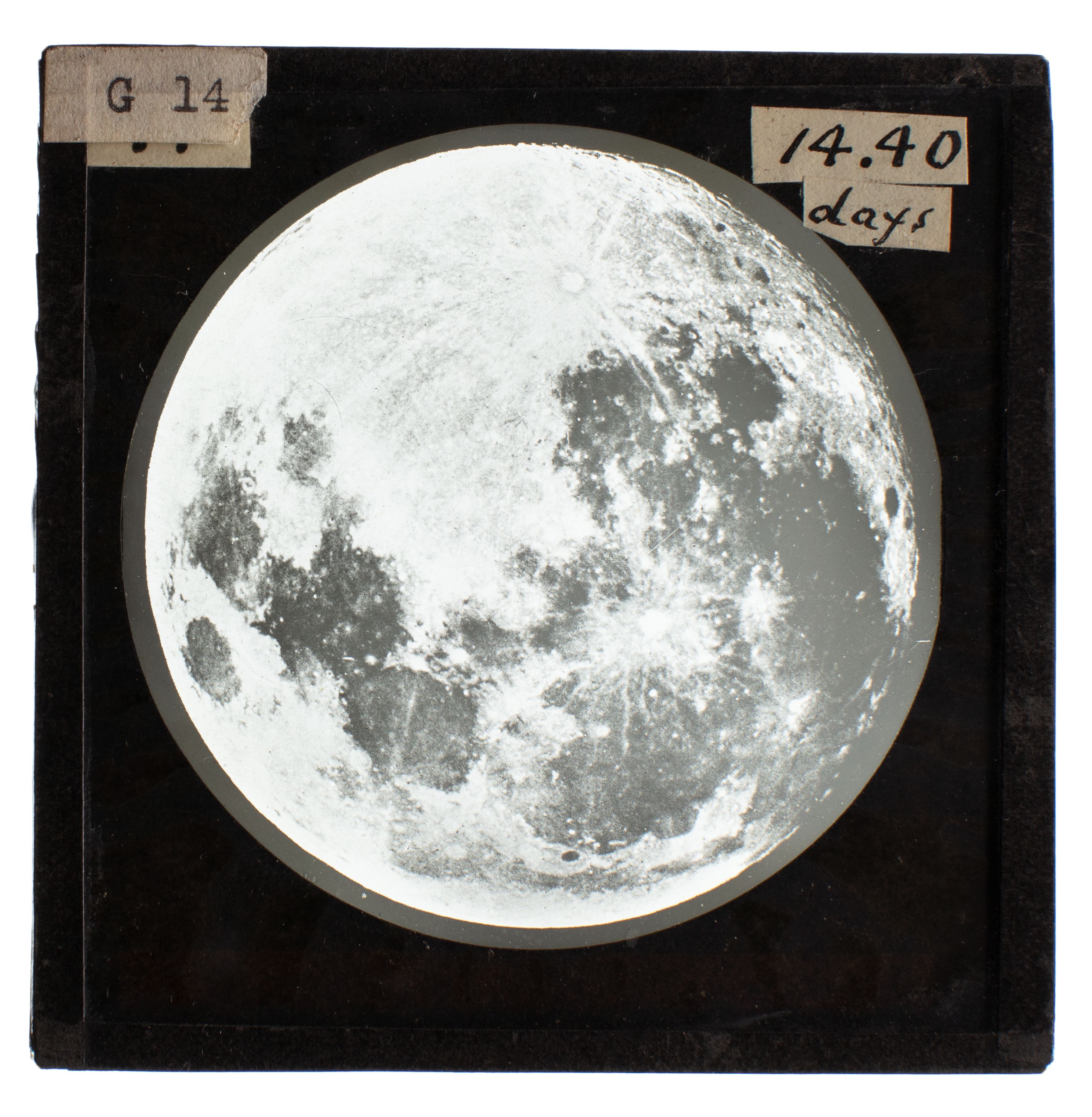 Black and white image of the moon in a black frame, a glass slide used for teaching astronomy.